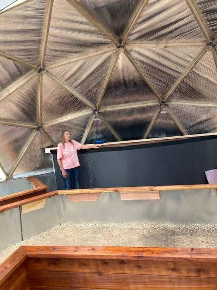 women standing next to pond in dome greenhouse in Colorado