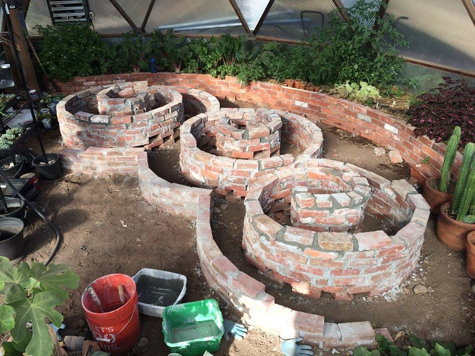 using bricks to create circular raised beds in growing dome greenhouse