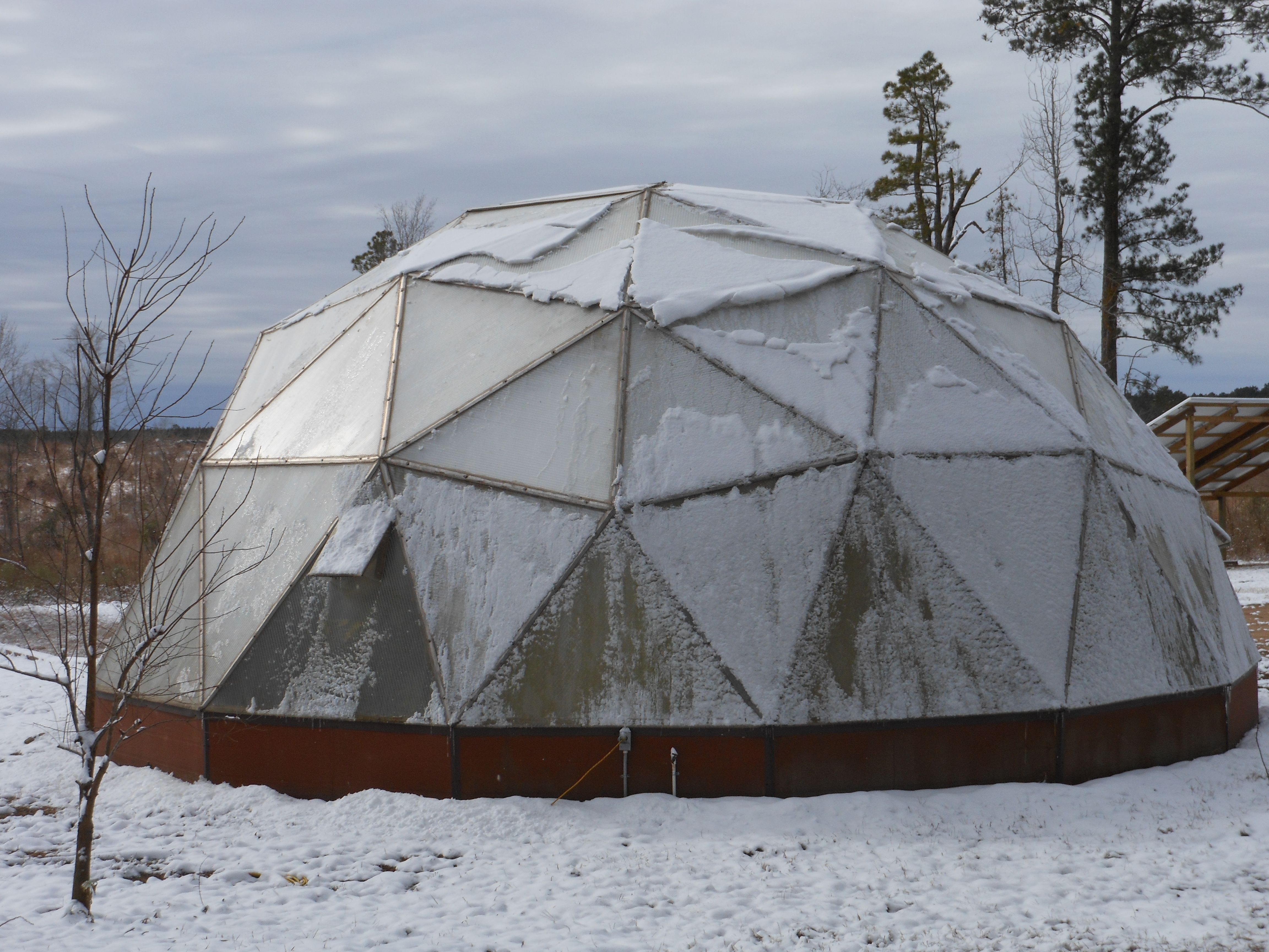 growing dome greenhouse crusted with icy snow