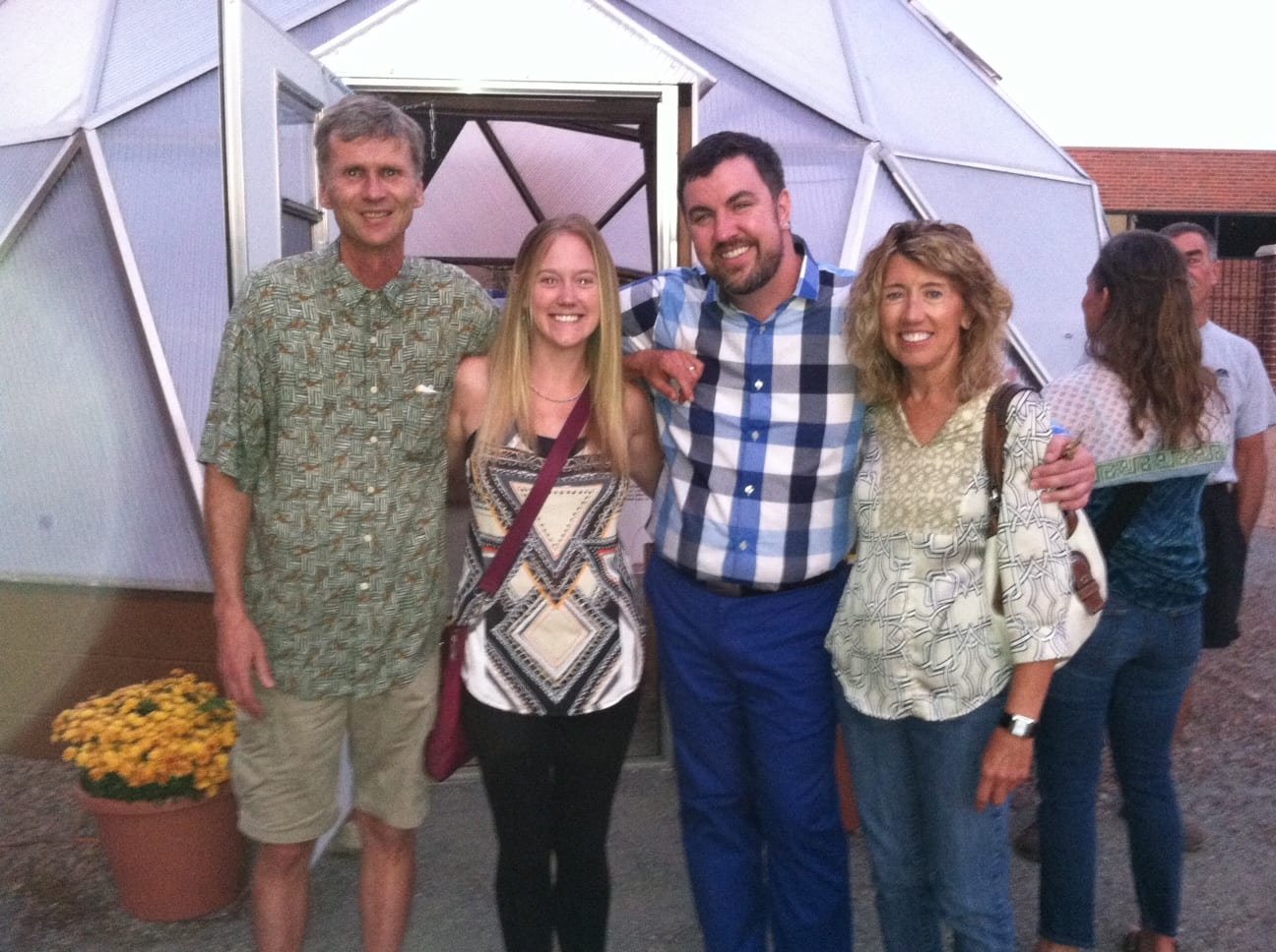 Four people standing in front of the greenhouse at Littleton Academy