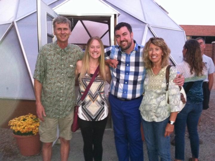 Four people standing in front of the greenhouse at Littleton Academy