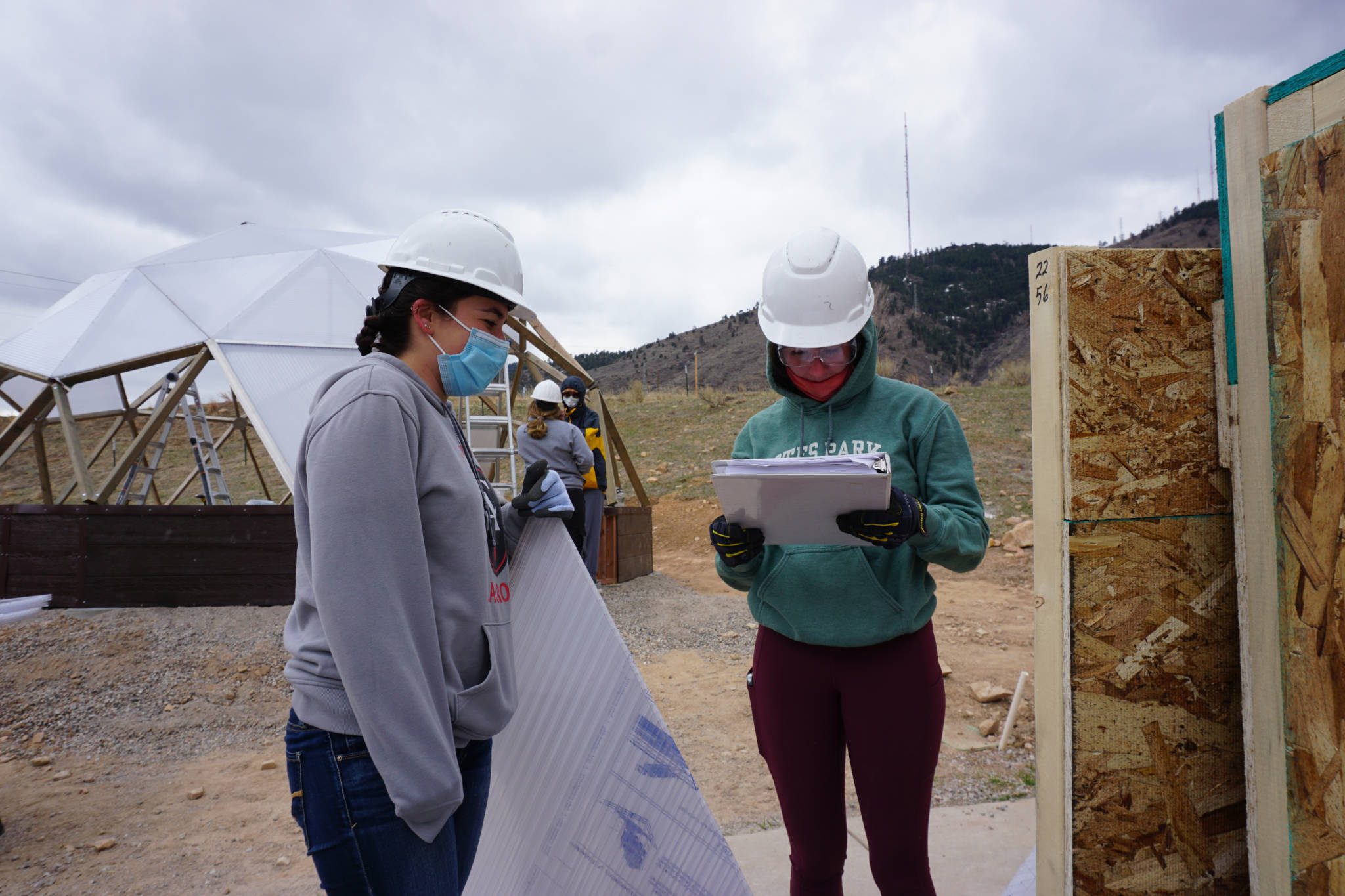 Students checking the inventory of parts for a growing dome greenhouse