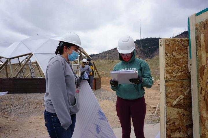 Students checking the inventory of parts for a growing dome greenhouse