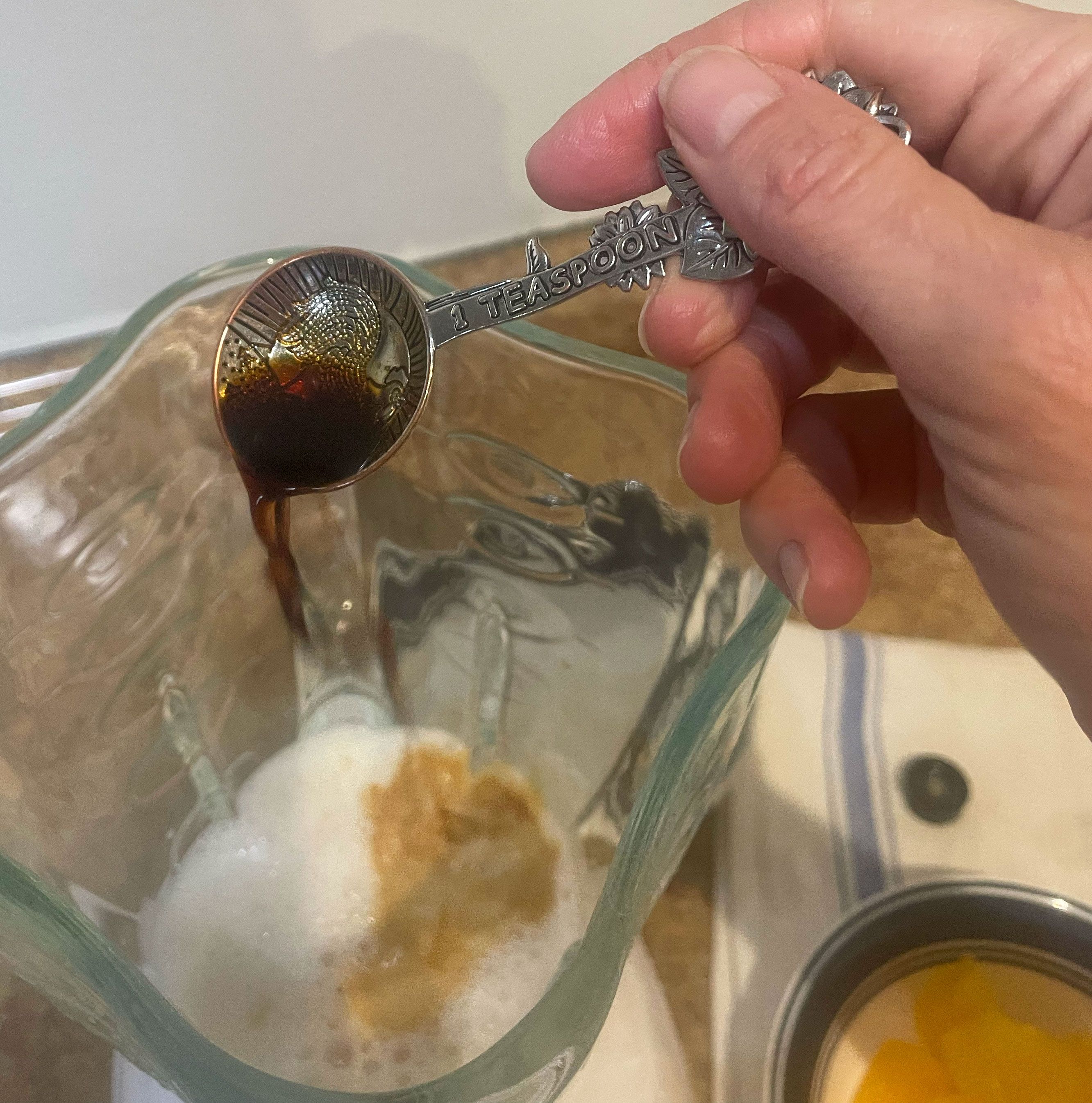 adding vanilla to the blender with almond milk