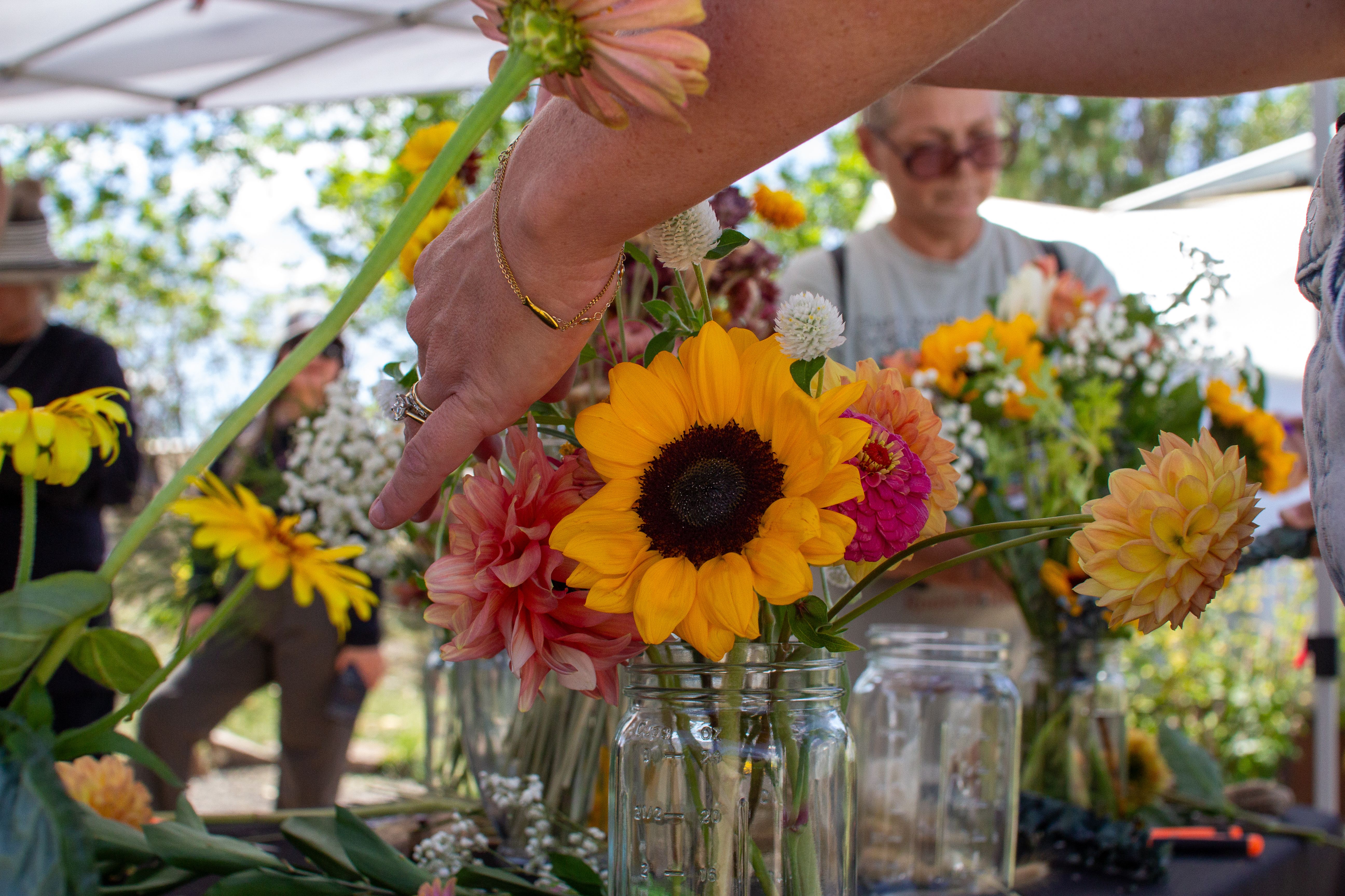 Close up of a sunflower in a bouquet with people in the background