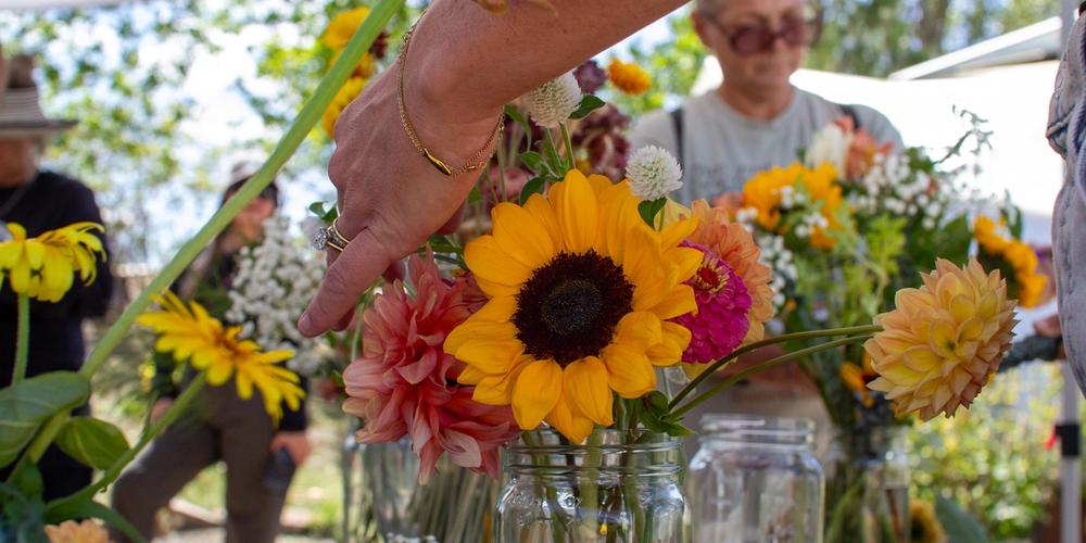 Close up of a sunflower in a bouquet with people in the background