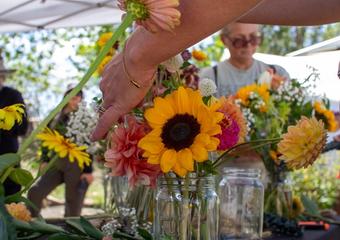 Close up of a sunflower in a bouquet with people in the background