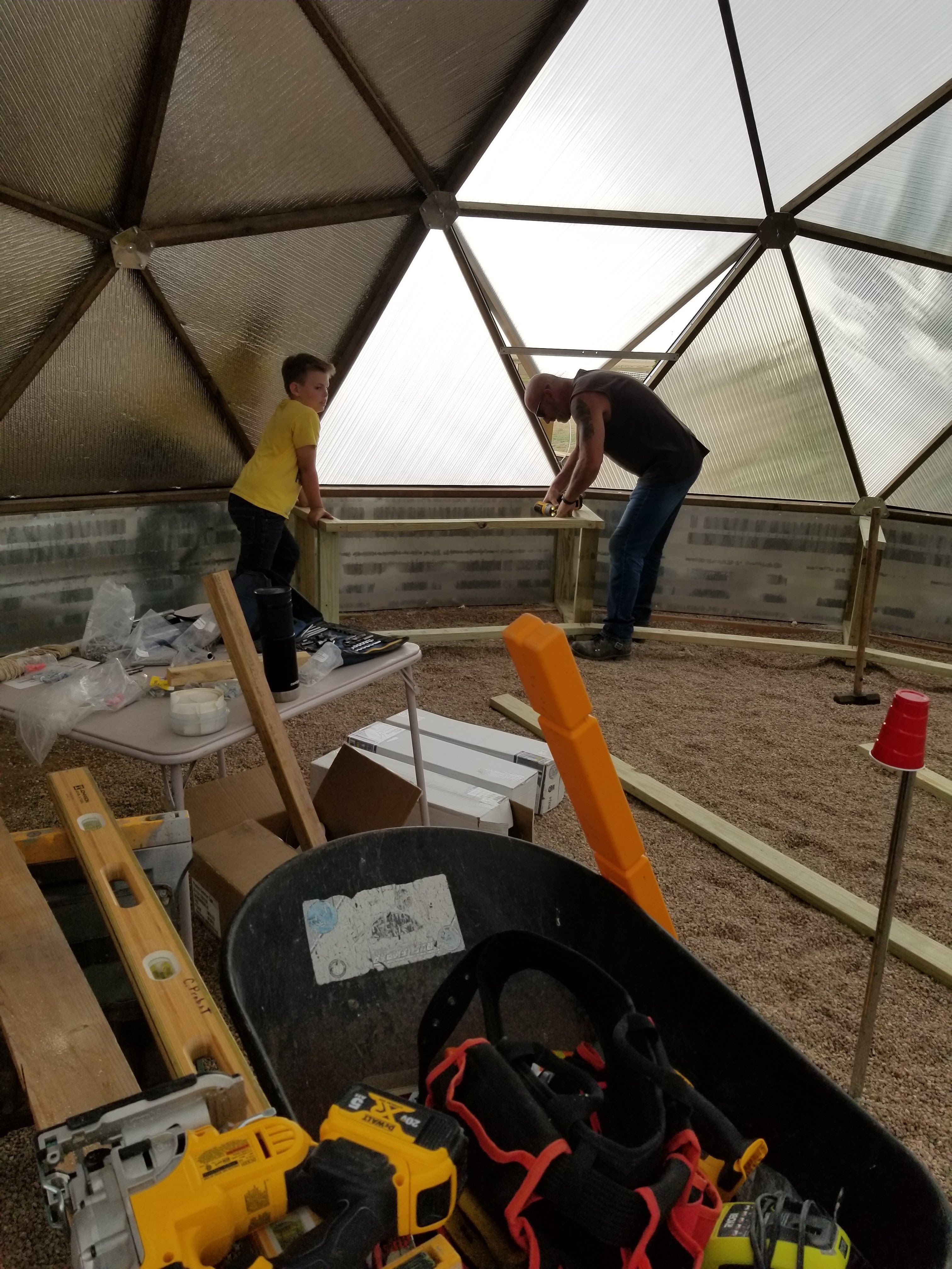 friends helping build Probst dome constructing raised beds inside the greenhouse