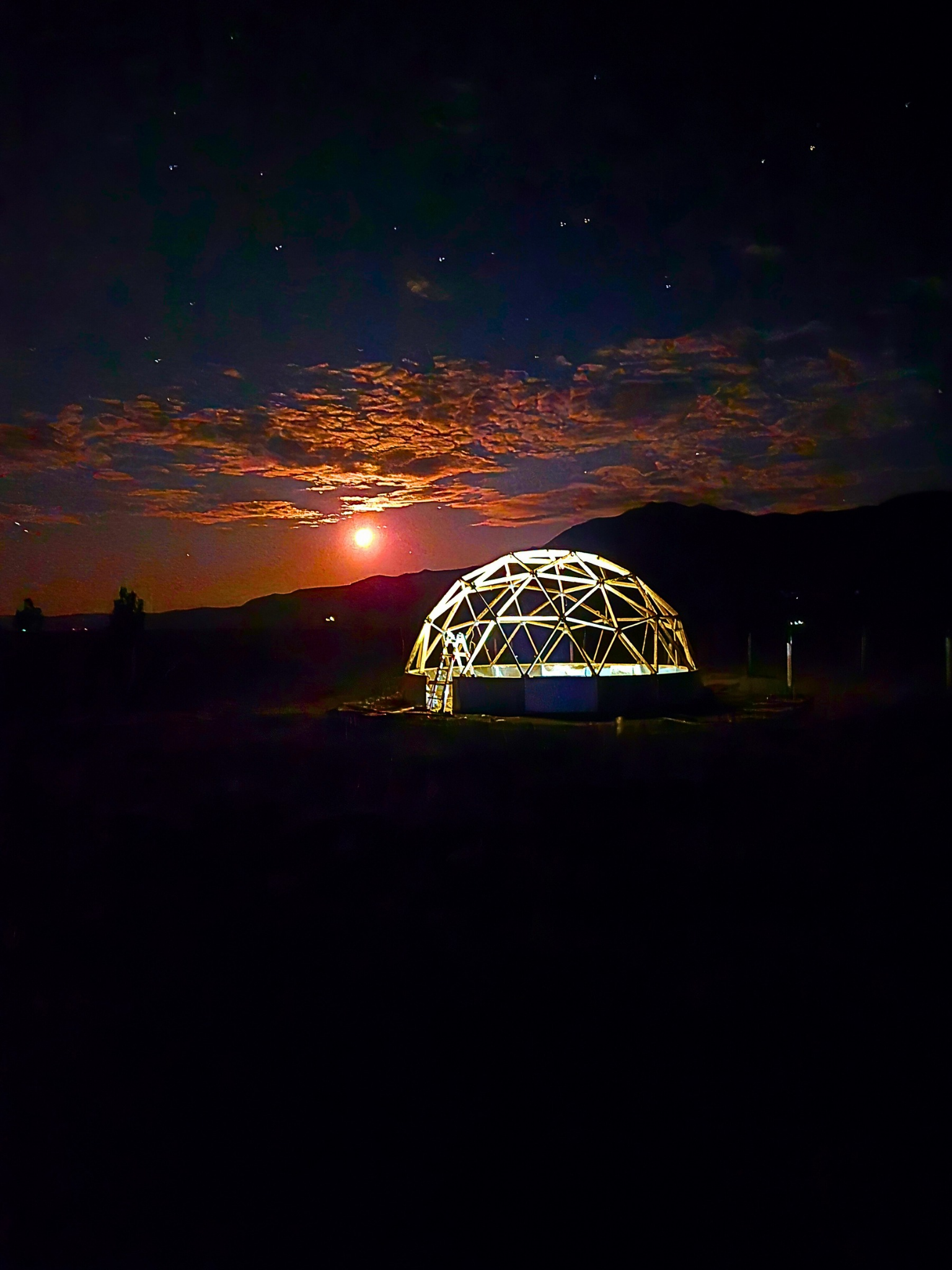 dome greenhouse under construction in Laramie WY framing lit up at night