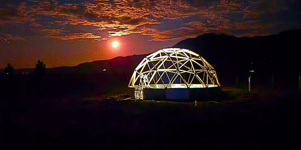 dome greenhouse under construction in Laramie WY framing lit up at night