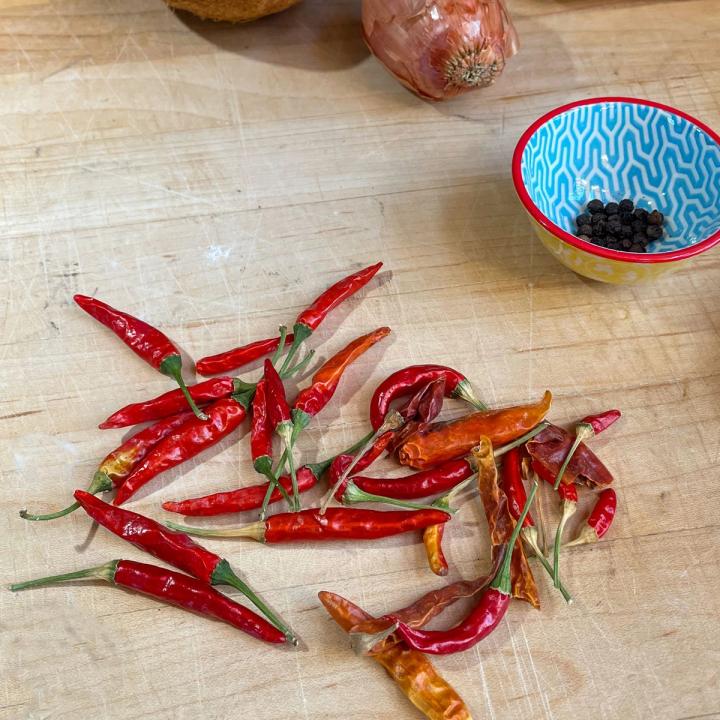 dried Thai chiles on a wooden cutting board