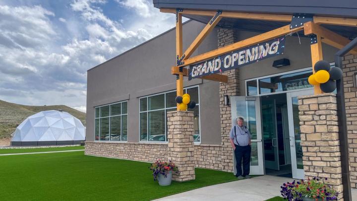 Exterior of the Rio Grande Hospital Wellness Center featuring the "grand opening" banner and balloons with Growing Dome greenhouse in background