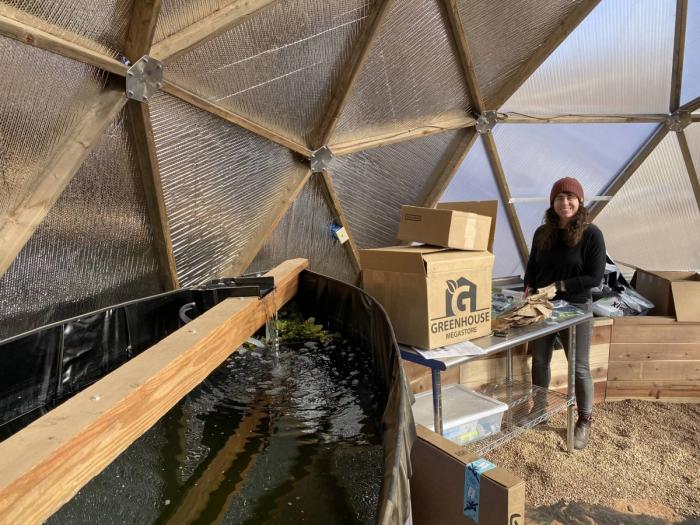 Shannon Harker setting up a solar-powered drip irrigation system in the 26' Growing Dome Greenhouse
