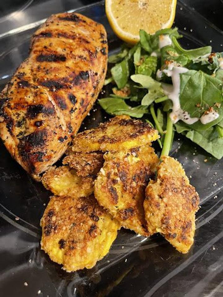 Sauté Summer Squash with Grilled Chicken and Dome Greens Salad plated with a lemon