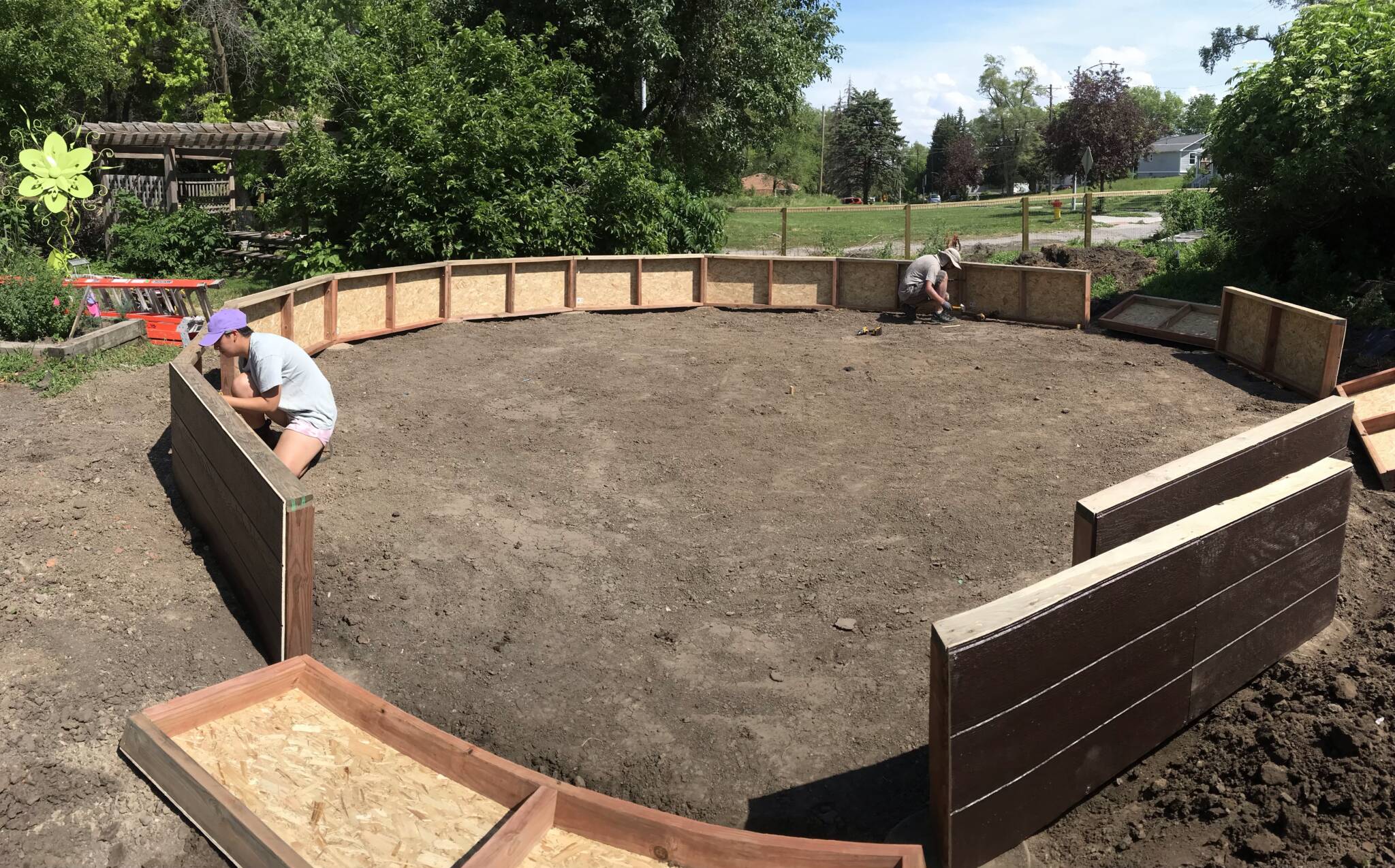 Volunteers attaching wall sections of a 26-foot Growing Dome greenhouse