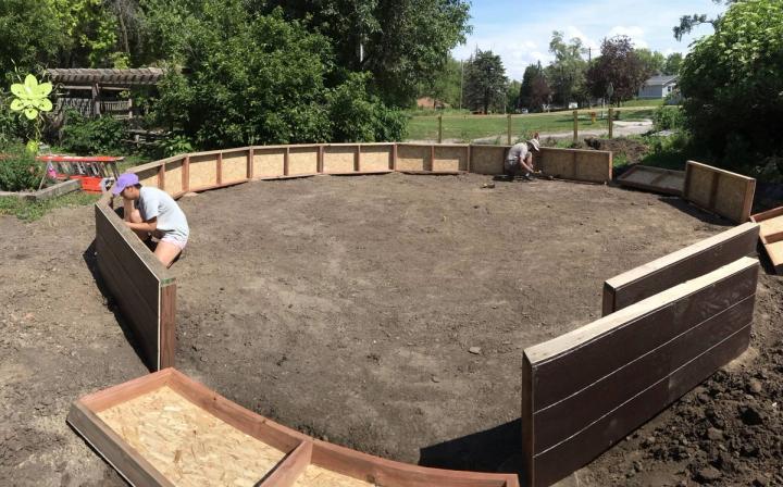 Volunteers attaching wall sections of a 26-foot Growing Dome greenhouse