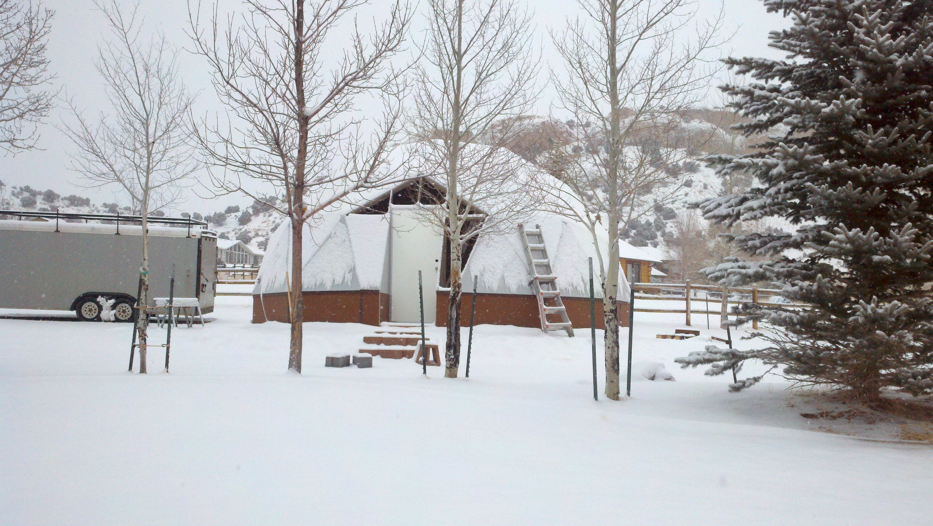 Snow-covered 26-foot Growing Dome greenhouse on a Utah property