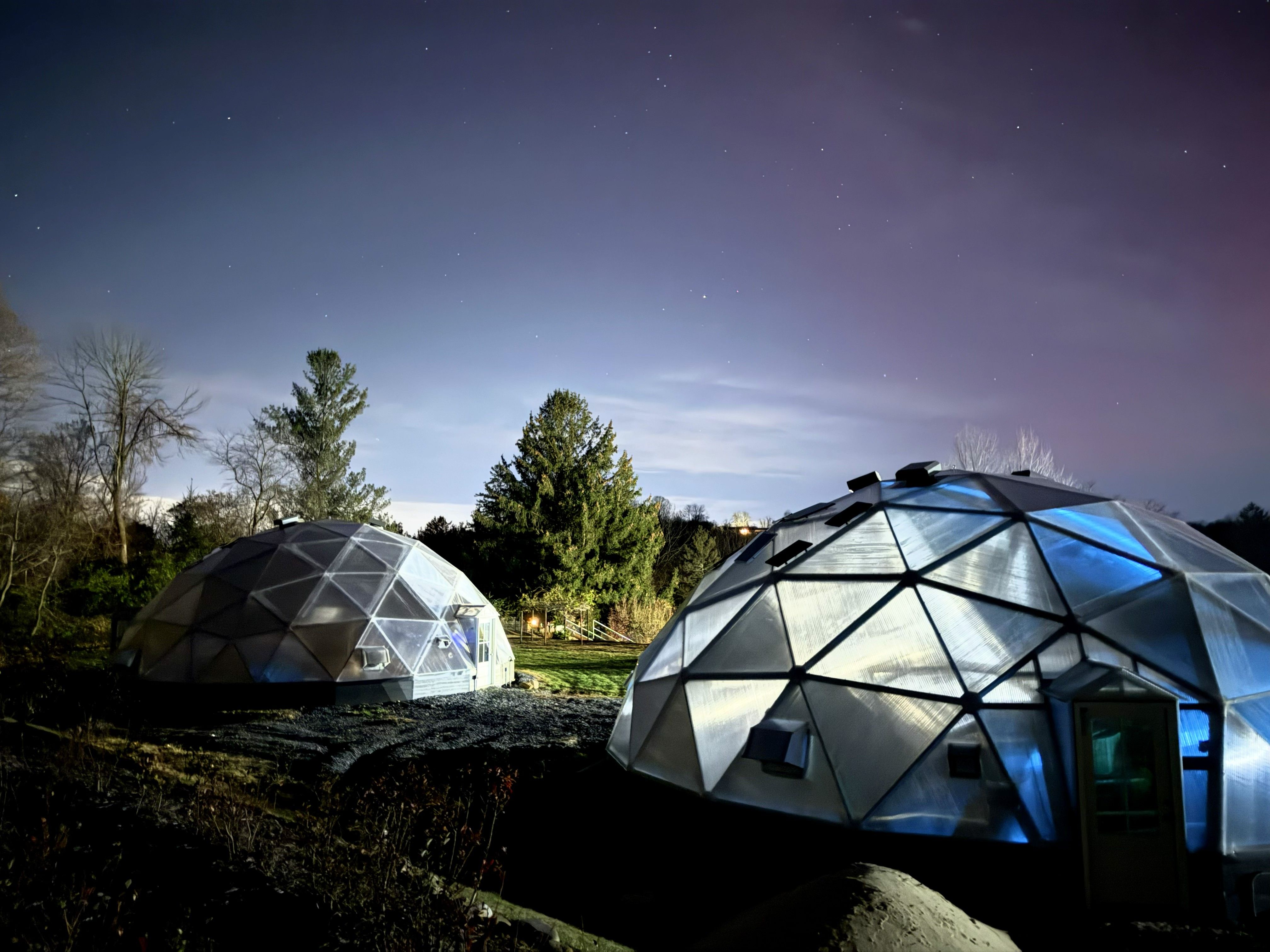 Kula Kamala dome greenhouses glow under aurora borealis