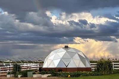Growing Dome greenhouse flanked by white horse fence in Kentucky