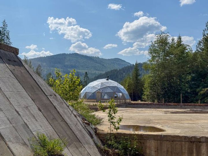42' Growing Dome in the Idaho mountains with a concrete bunker house in foreground