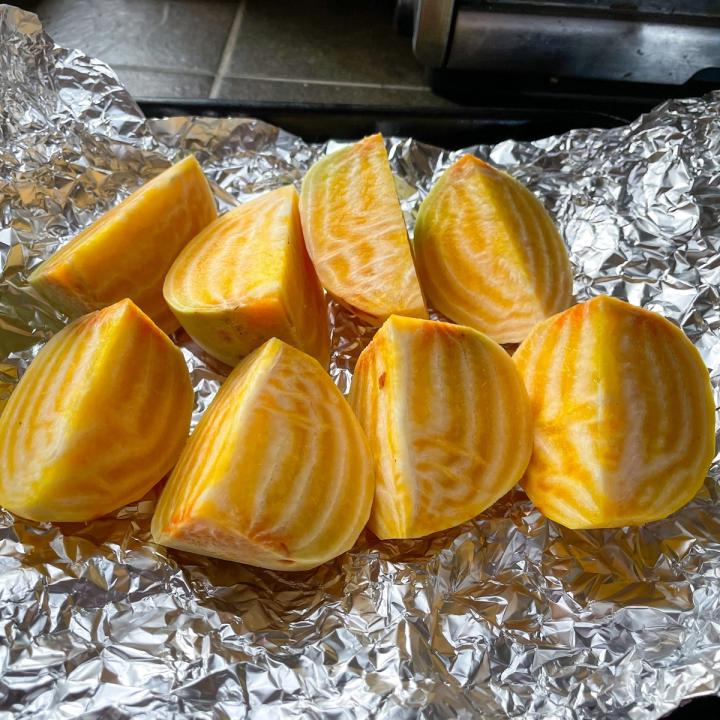 golden beets cleaned and quartered laying on a sheet of foil