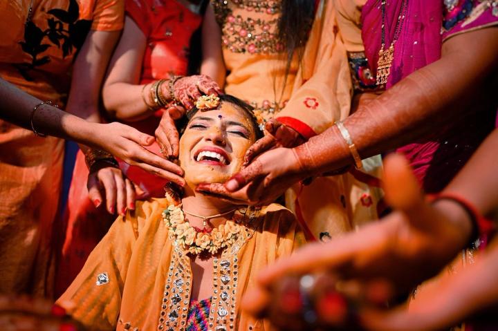 turmeric in wedding ceremony a woman being annointed by the hands of many other women
