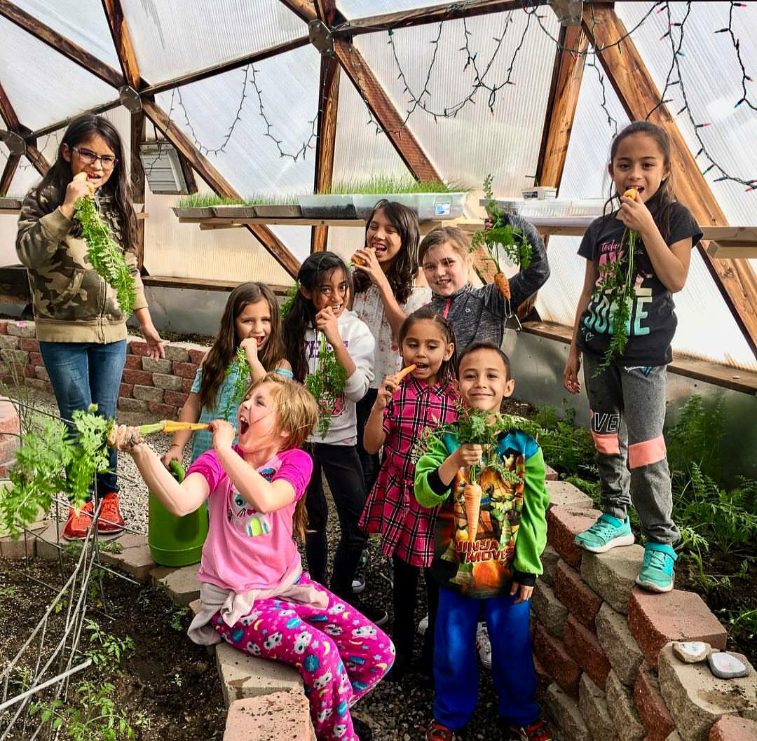 Students eat carrots fresh from the Growing Dome