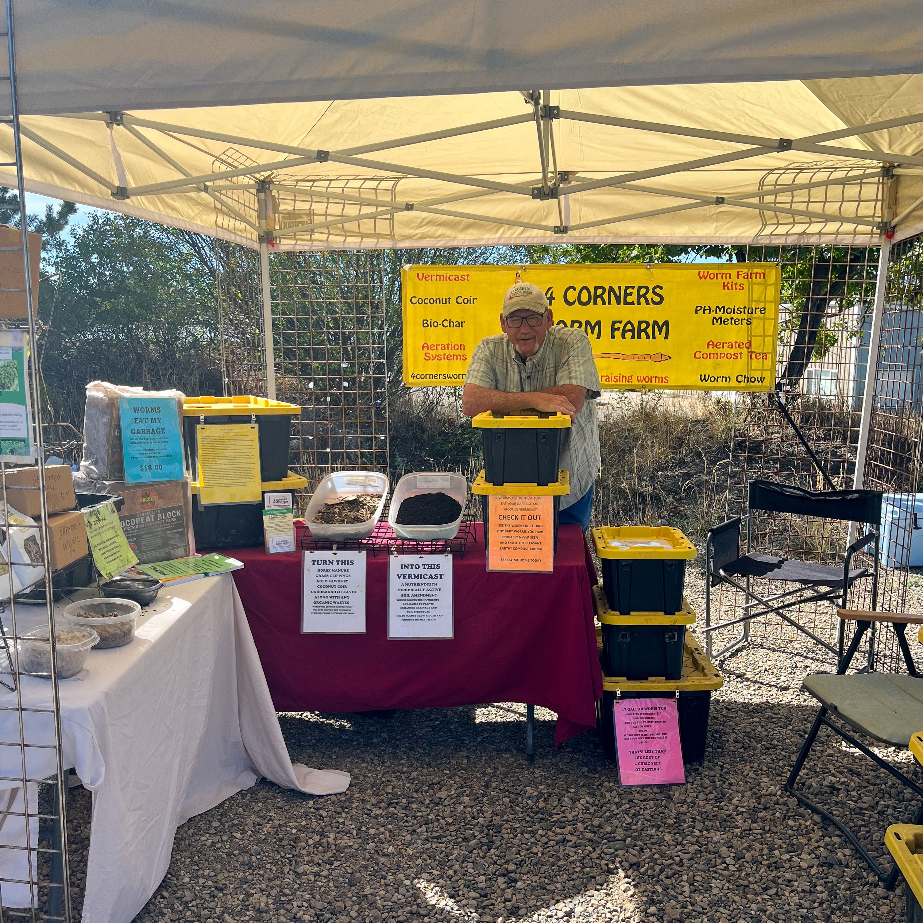 A man standing behind a worm bin at an even booth