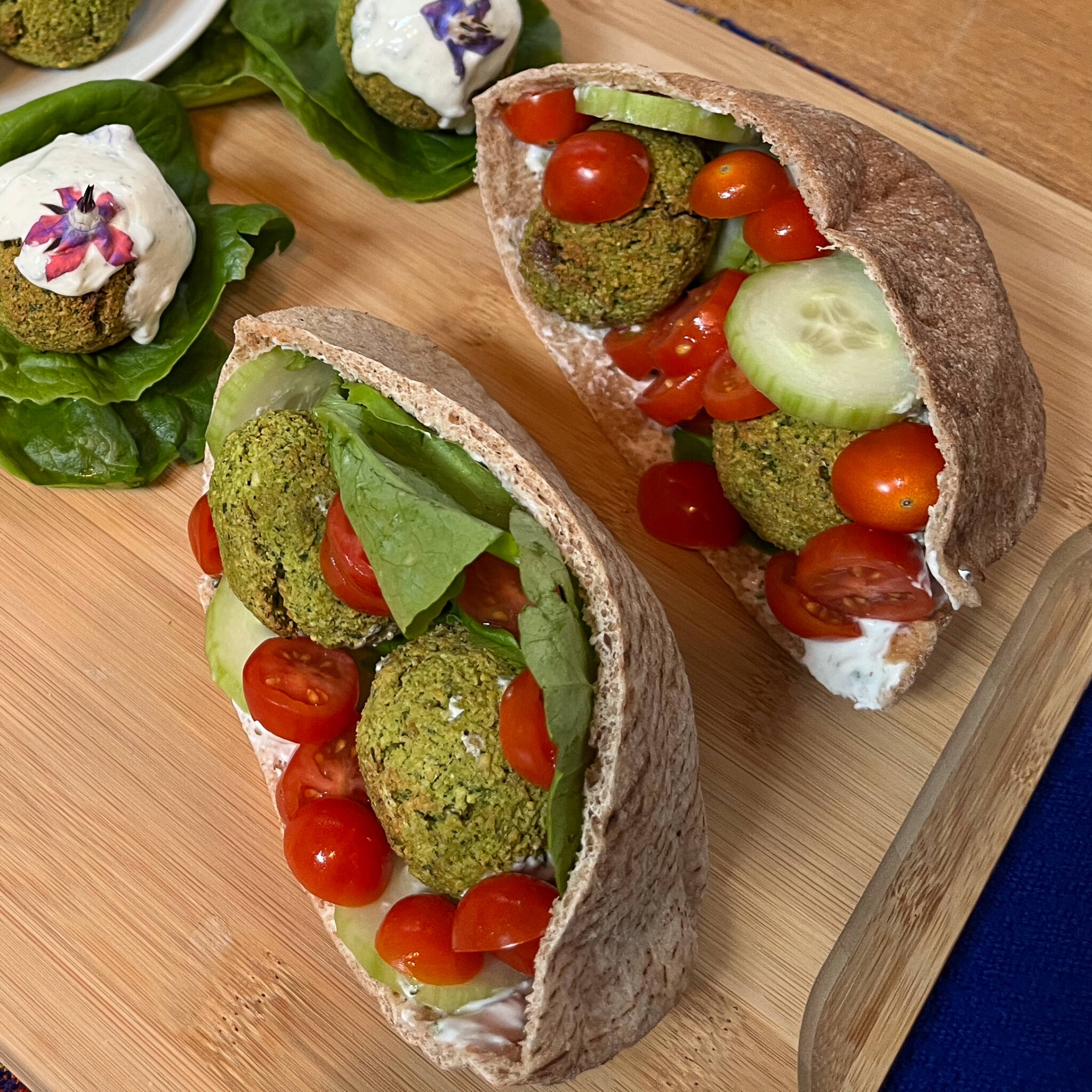 falafel placed in a pita with tzatziki cherry tomatoes and lettuce