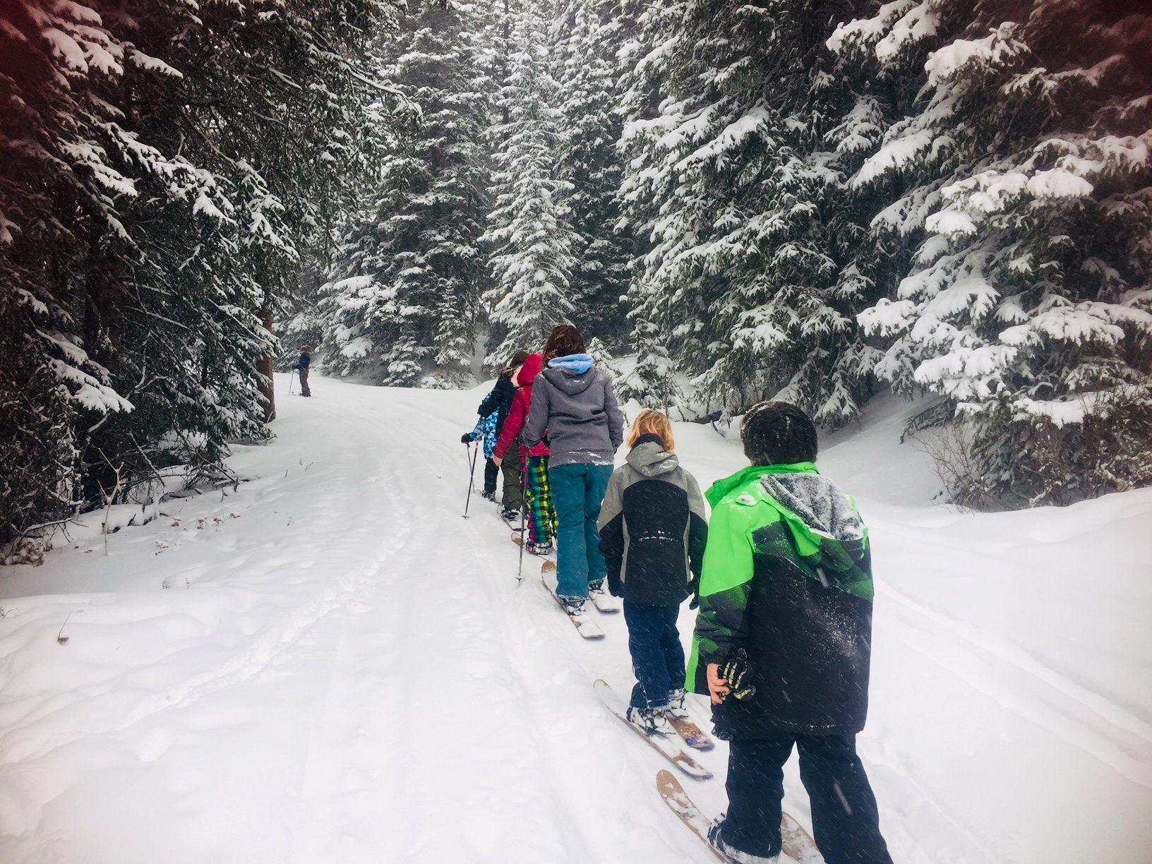 Cooke City students skiing through the snow near their Growing Dome