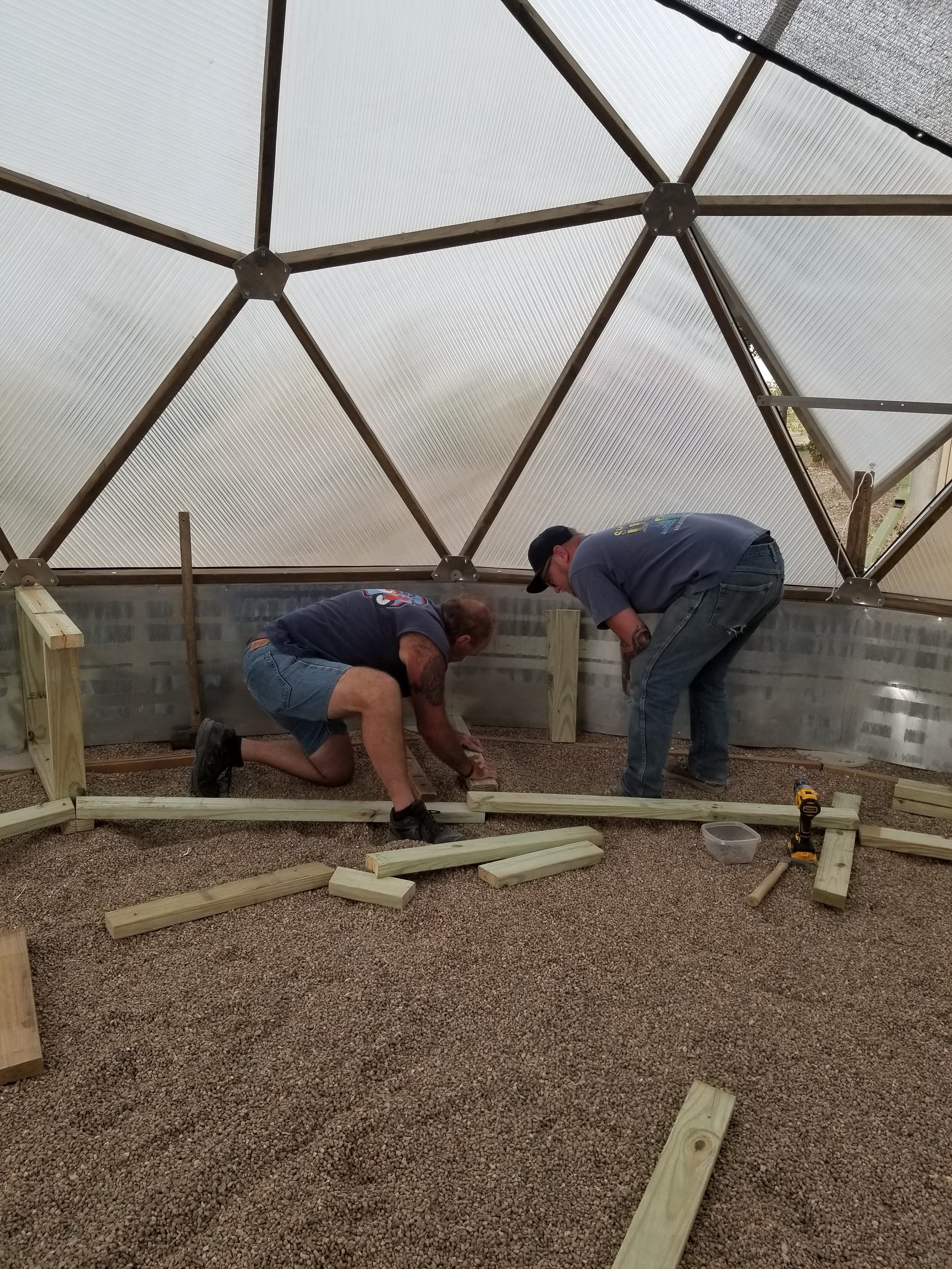 Two people installing interior components inside a Growing Dome in Nunn, Colorado