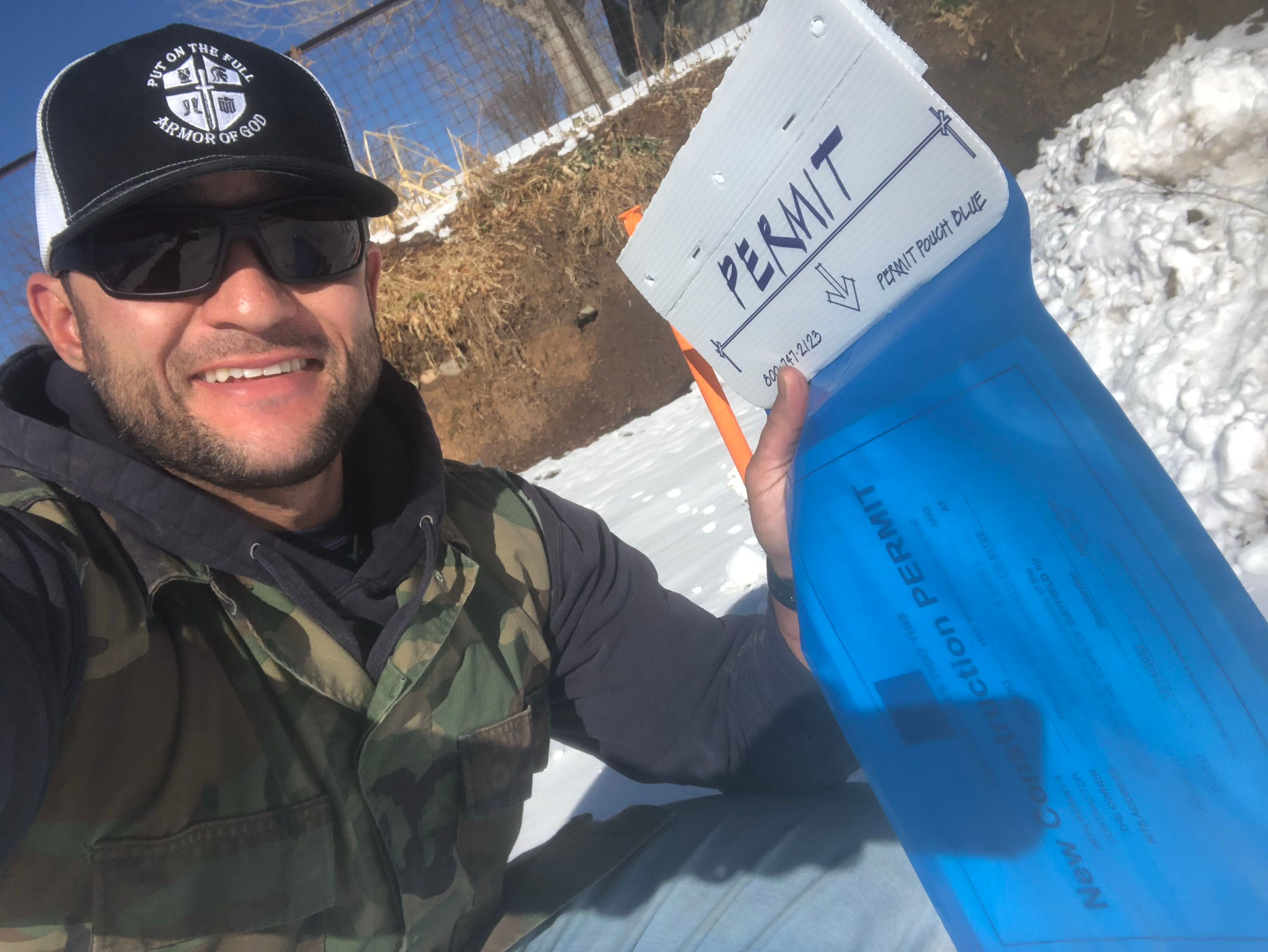 man smiling and holding a permit