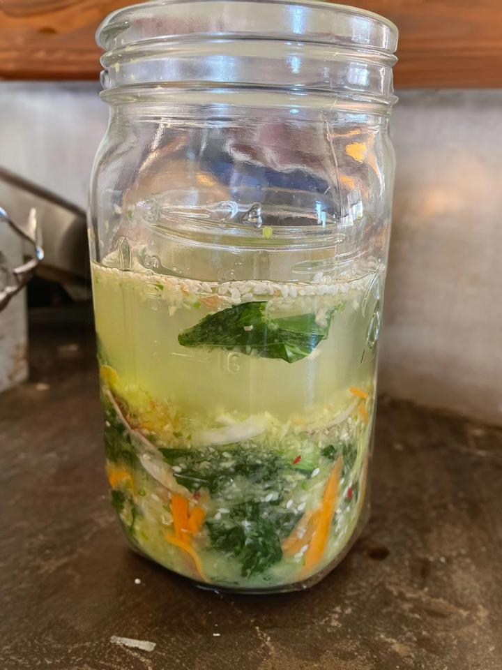 jar of kimchi sitting on the counter fermenting