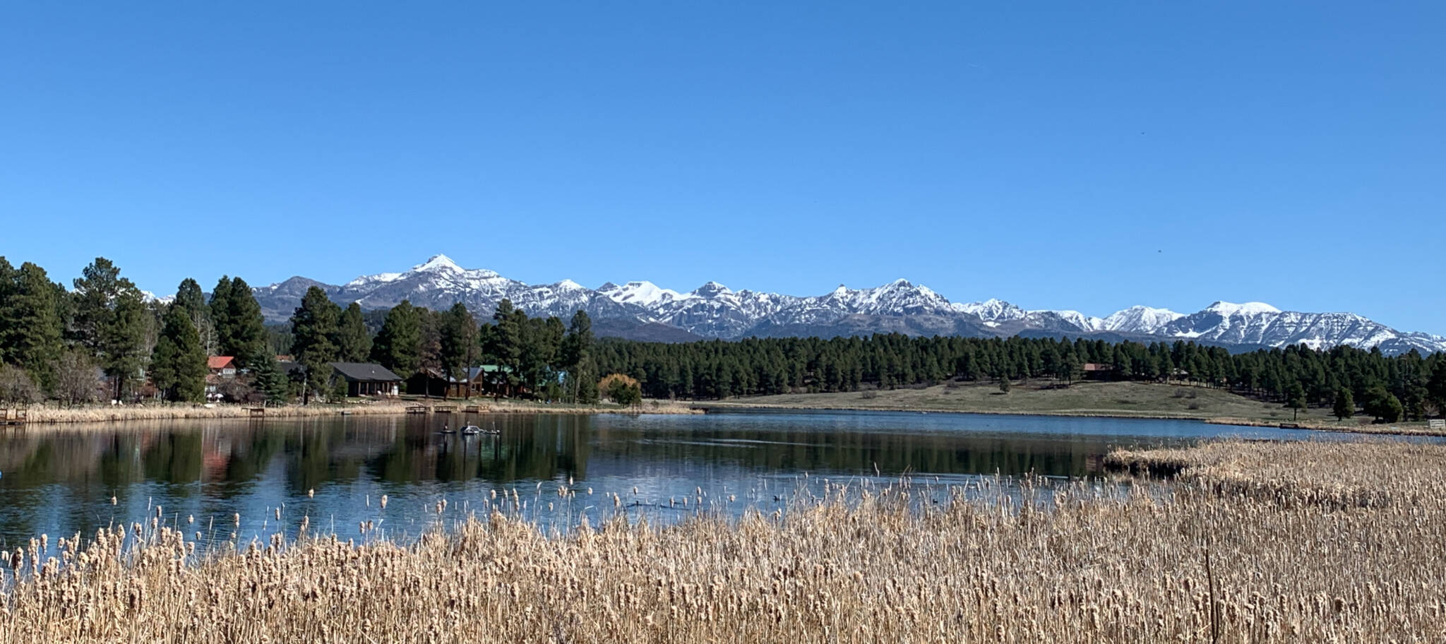 Pagosa Lake featuring a clear sky and  snow-capped mountains in the background
