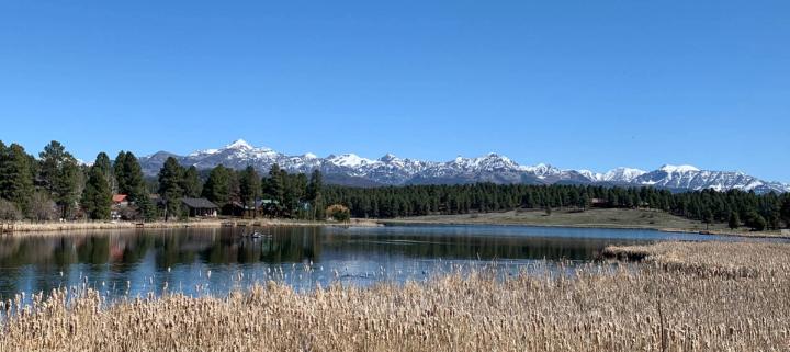 Pagosa Lake featuring a clear sky and  snow-capped mountains in the background