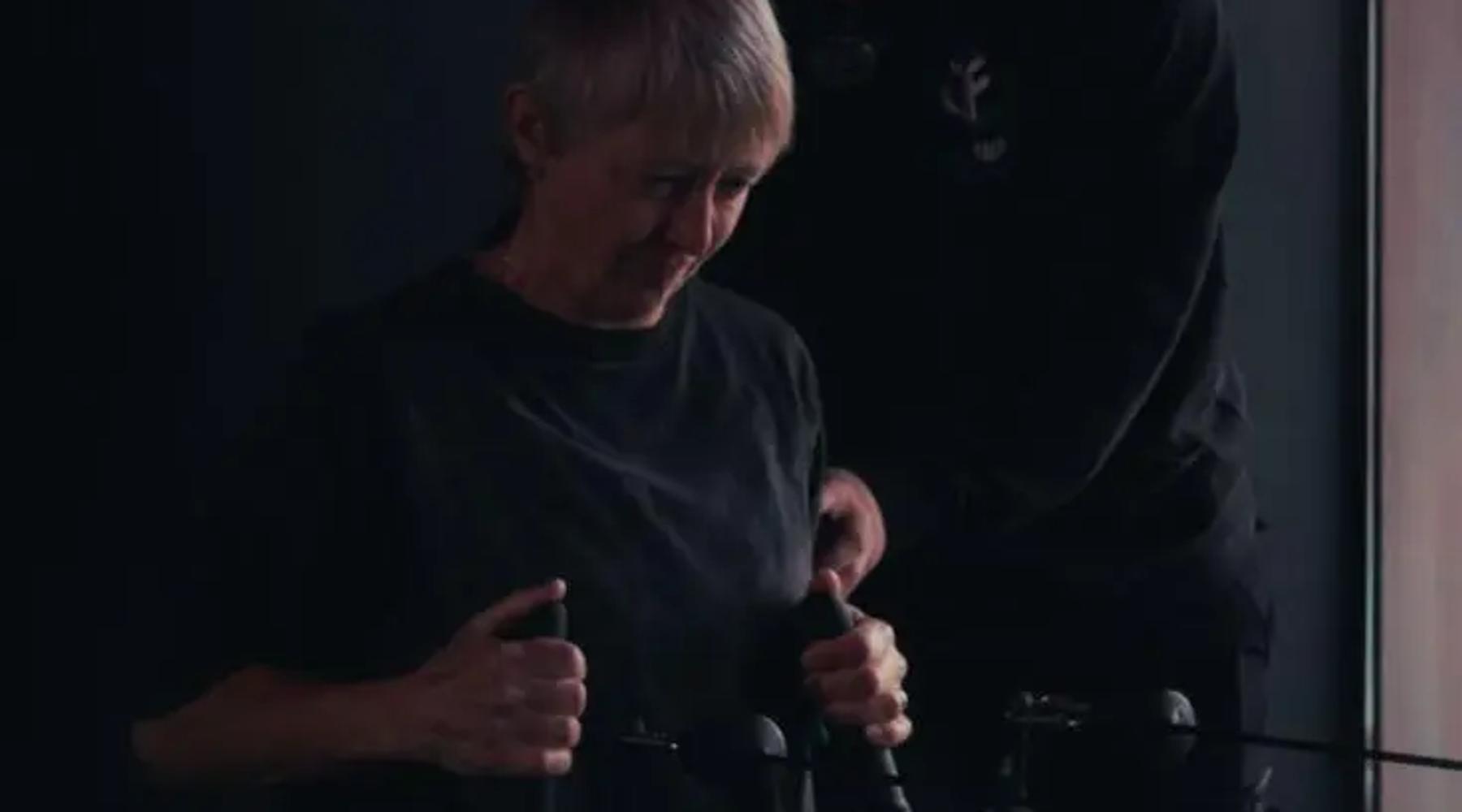 Coach guiding a member through a seated cable row, strength training for over 50s at TNT Fitness