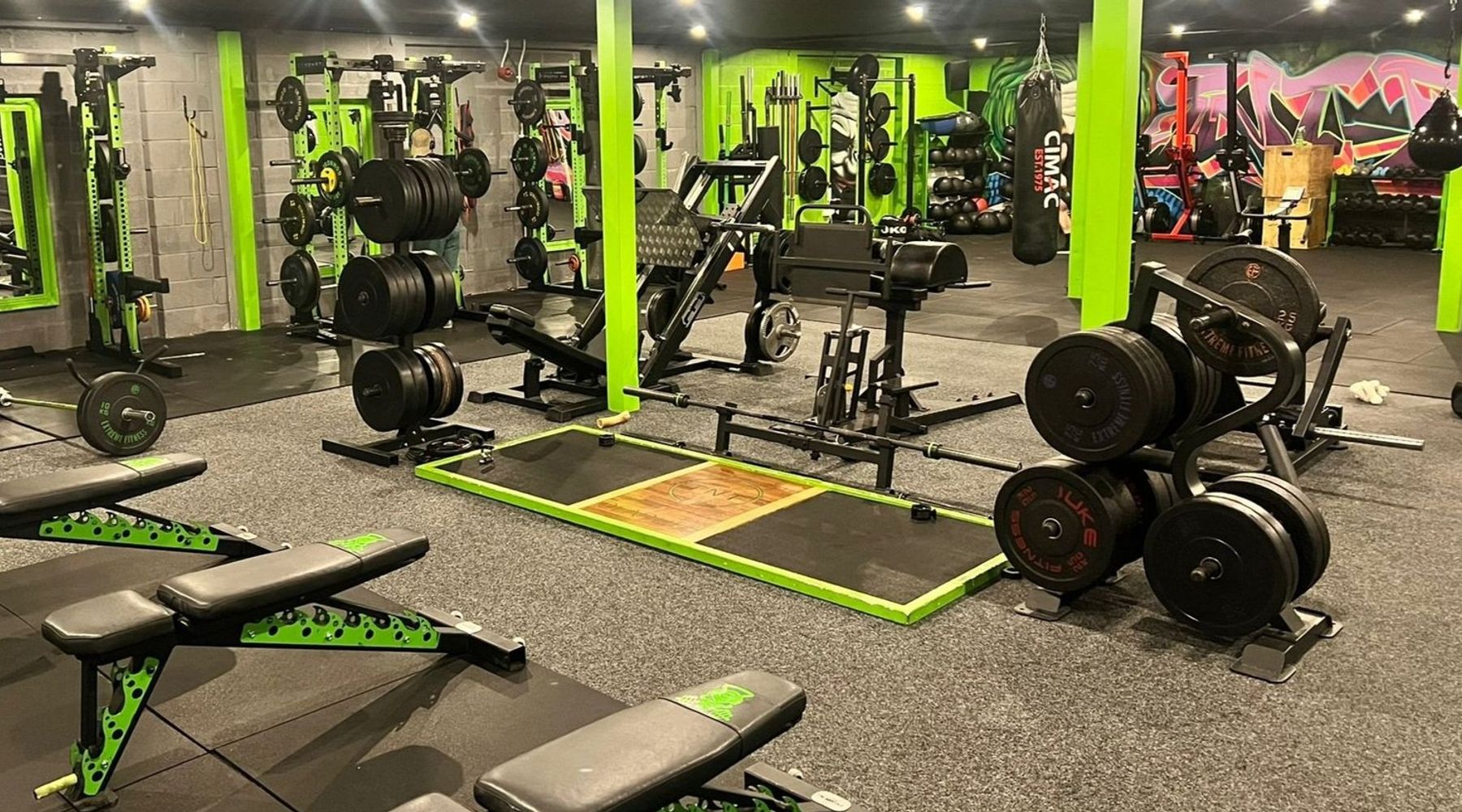 Weights floor at TNT Fitness, a gym near Carnforth, with benches, lifting platform and plates