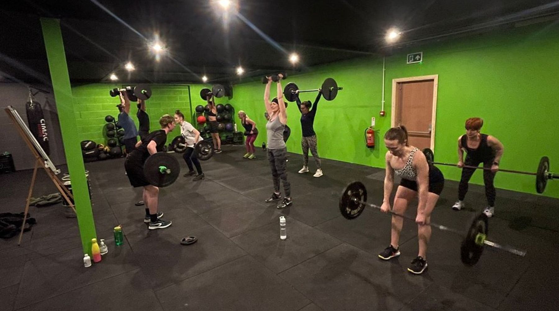 Members lifting barbells in a group class at TNT Fitness Cowan Bridge, staying consistent at the gym in winter