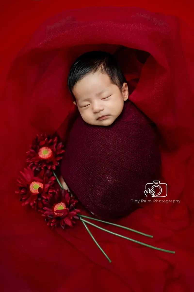 newborn sleeping in red clothes