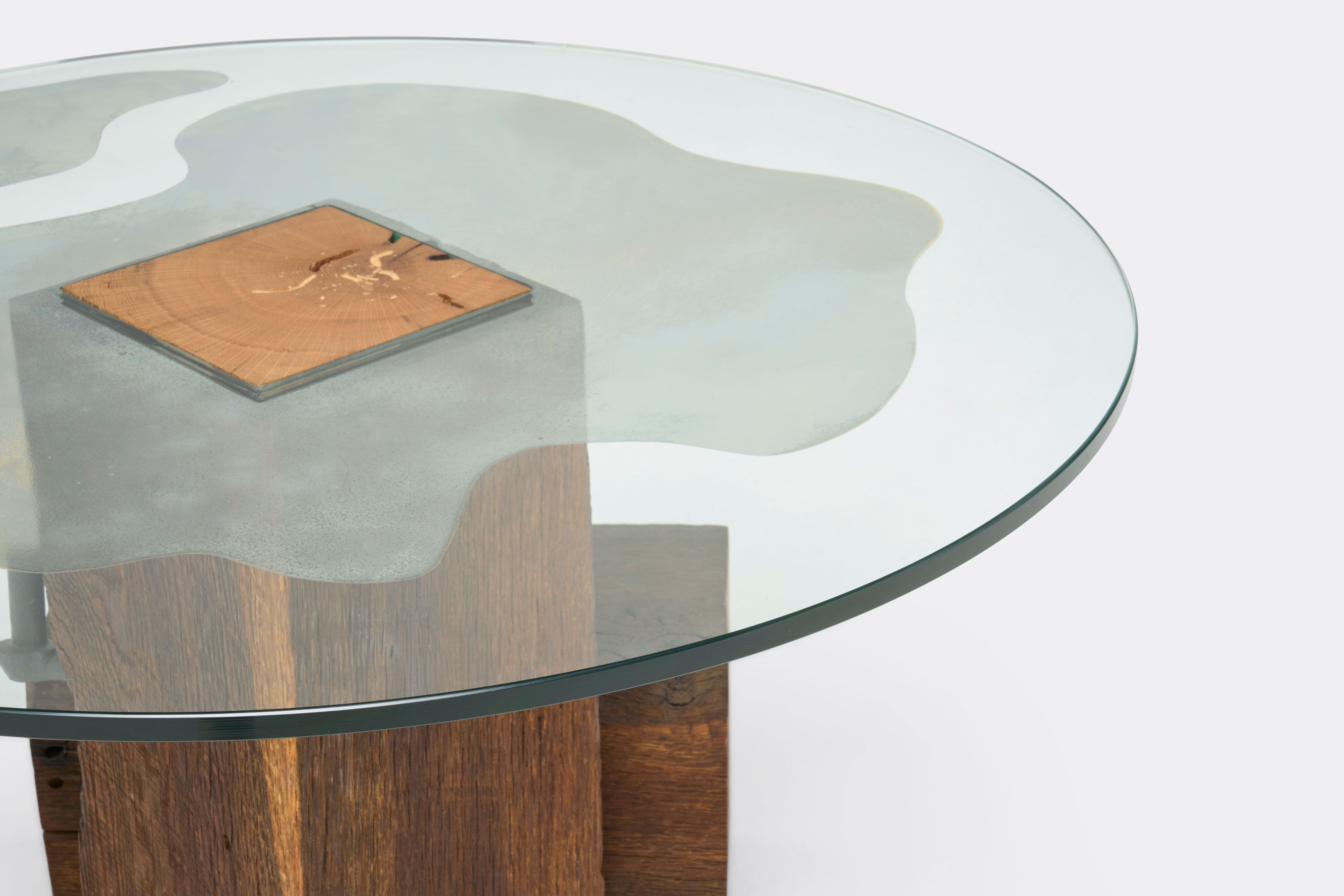 a coffee table with a glass top and a wooden base .