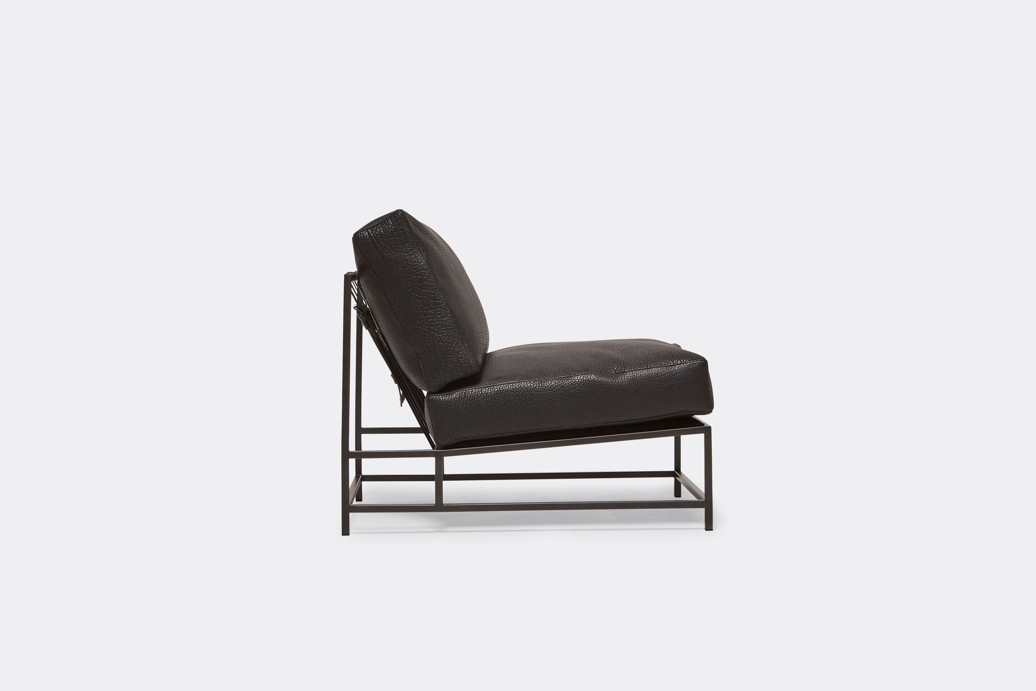 Sideview of lounge chair with black leather upholstery and black metal frame