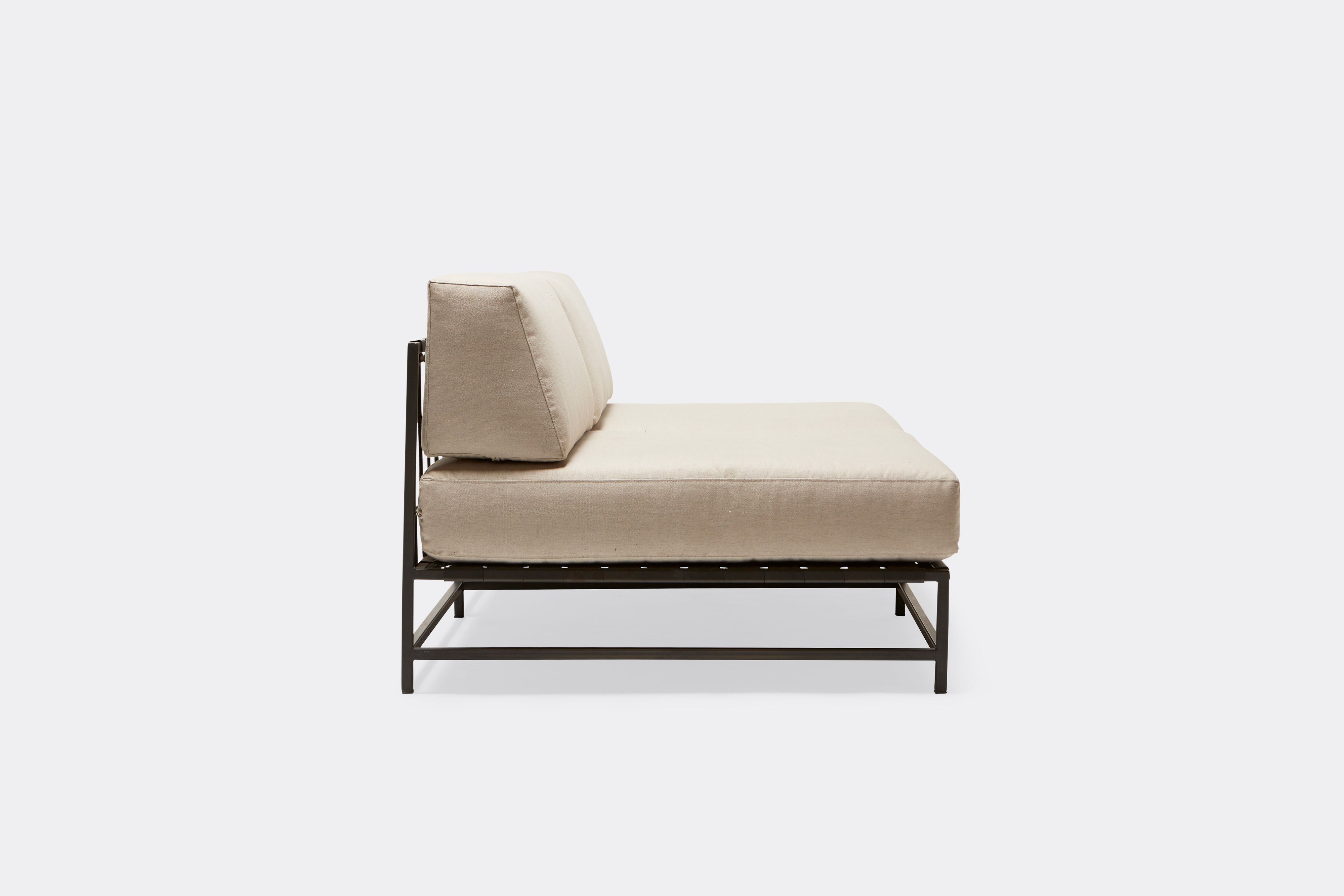 side of outdoor loveseat with cream canvas upholstery on dark grey metal frame