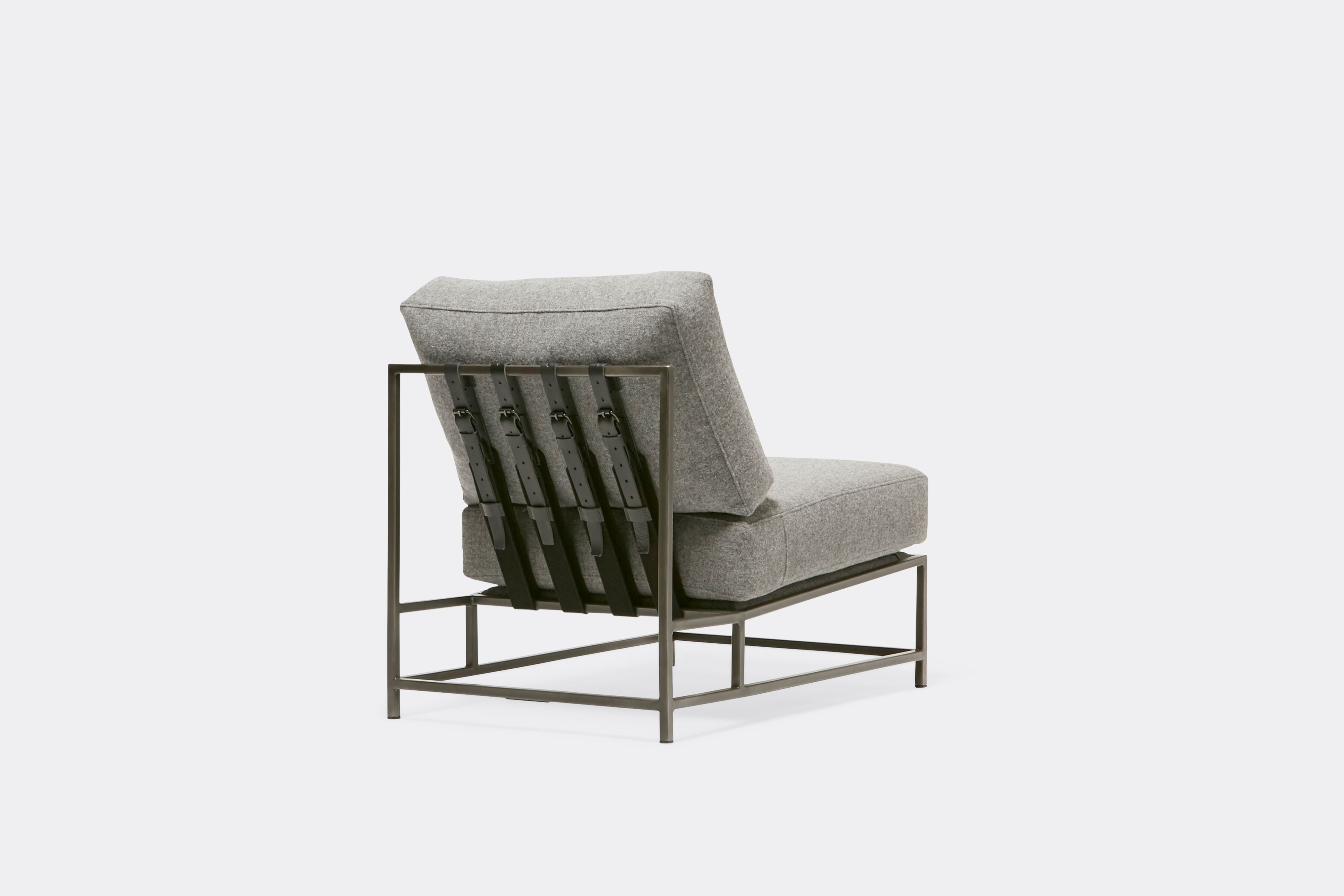 Back view of lounge chair with grey wool upholstery and grey leather belts on antique nickel metal frame