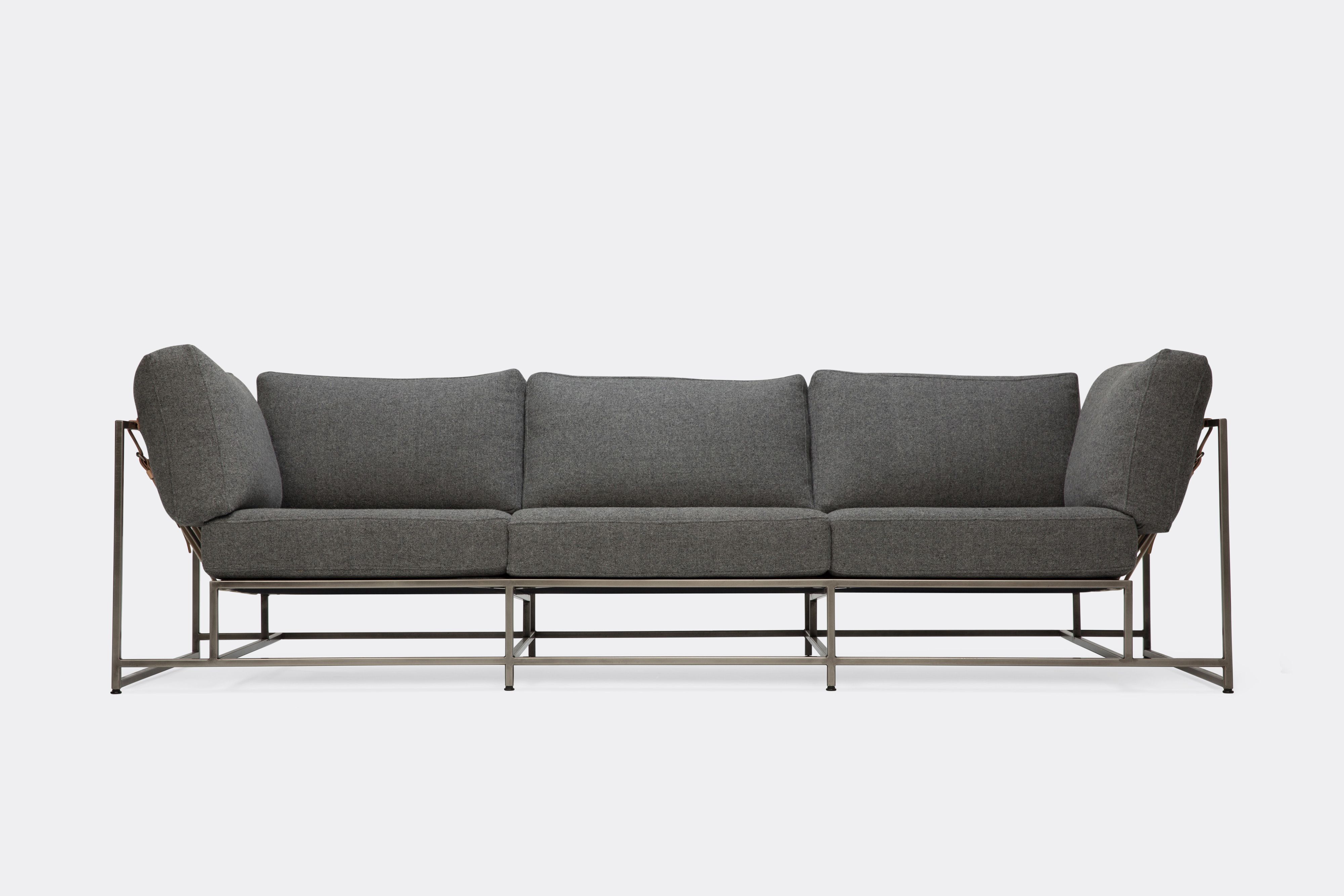 Front of sofa with grey wool upholstery and antique nickel metal frame