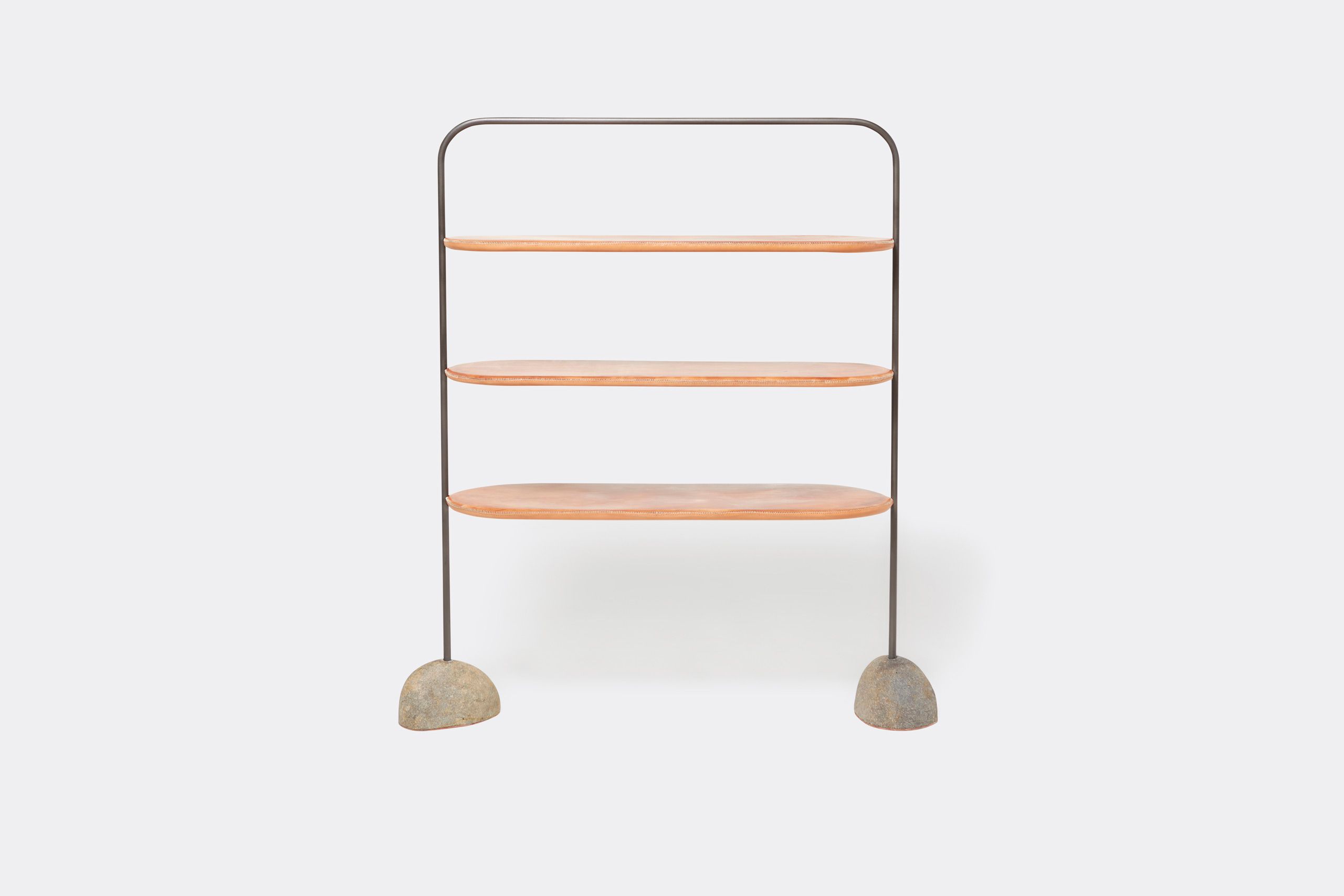 A leather wrapped steel framed shelf with stone bases. Shown on a white background with accent stones