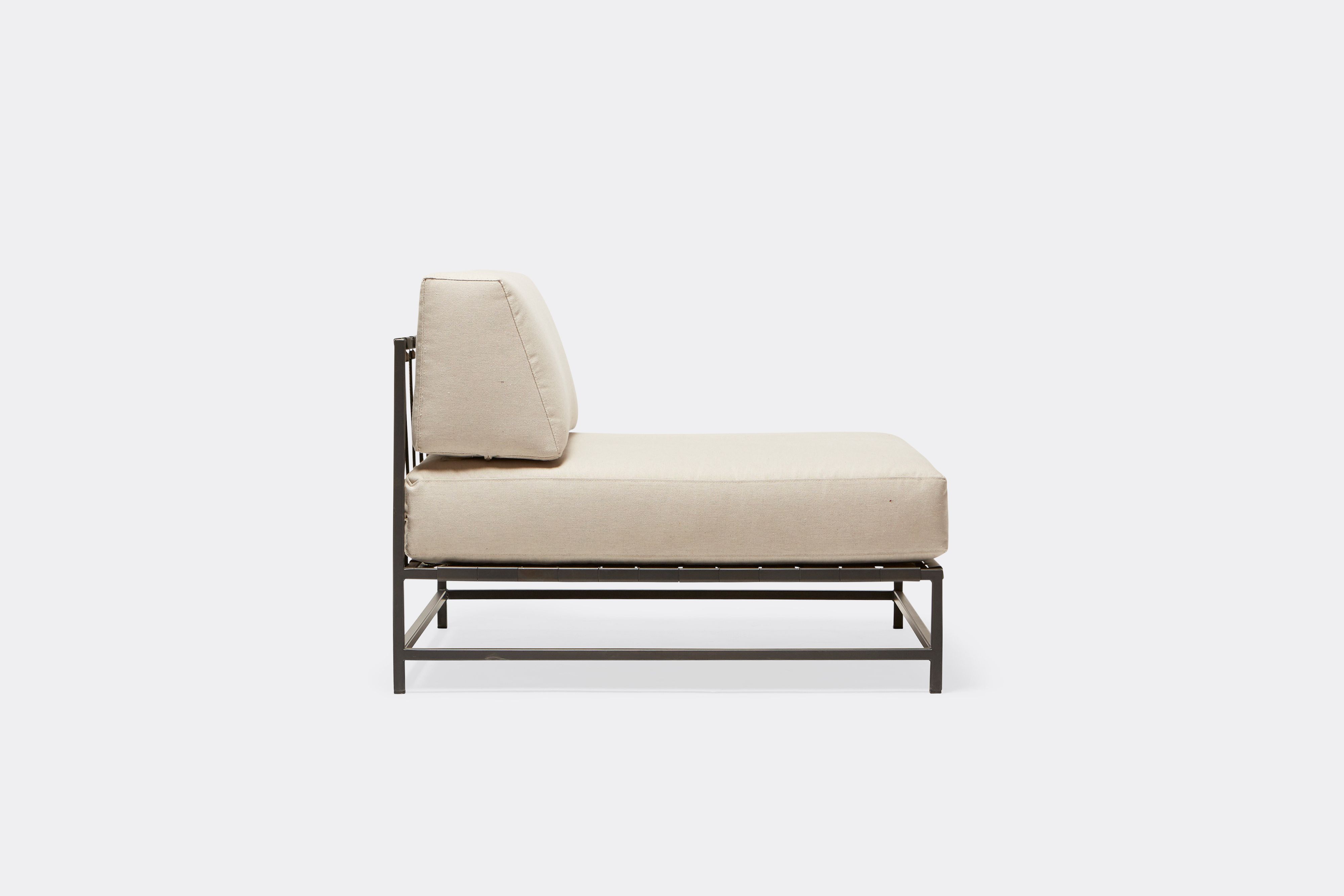 side of outdoor chair with cream canvas upholstery on charcoal metal frame