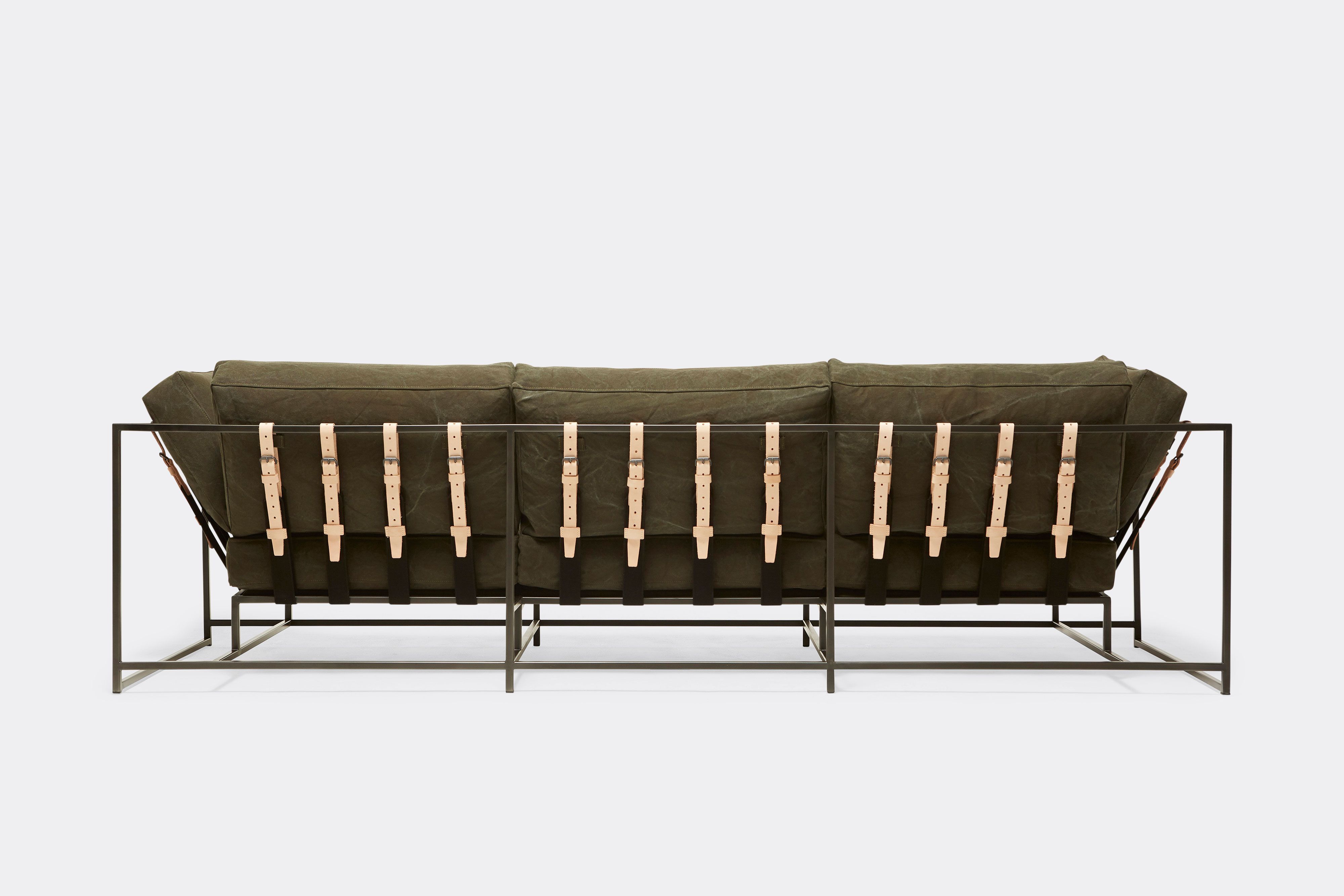 detail back of sofa with green canvas upholstery and natural leather belts on black metal frame