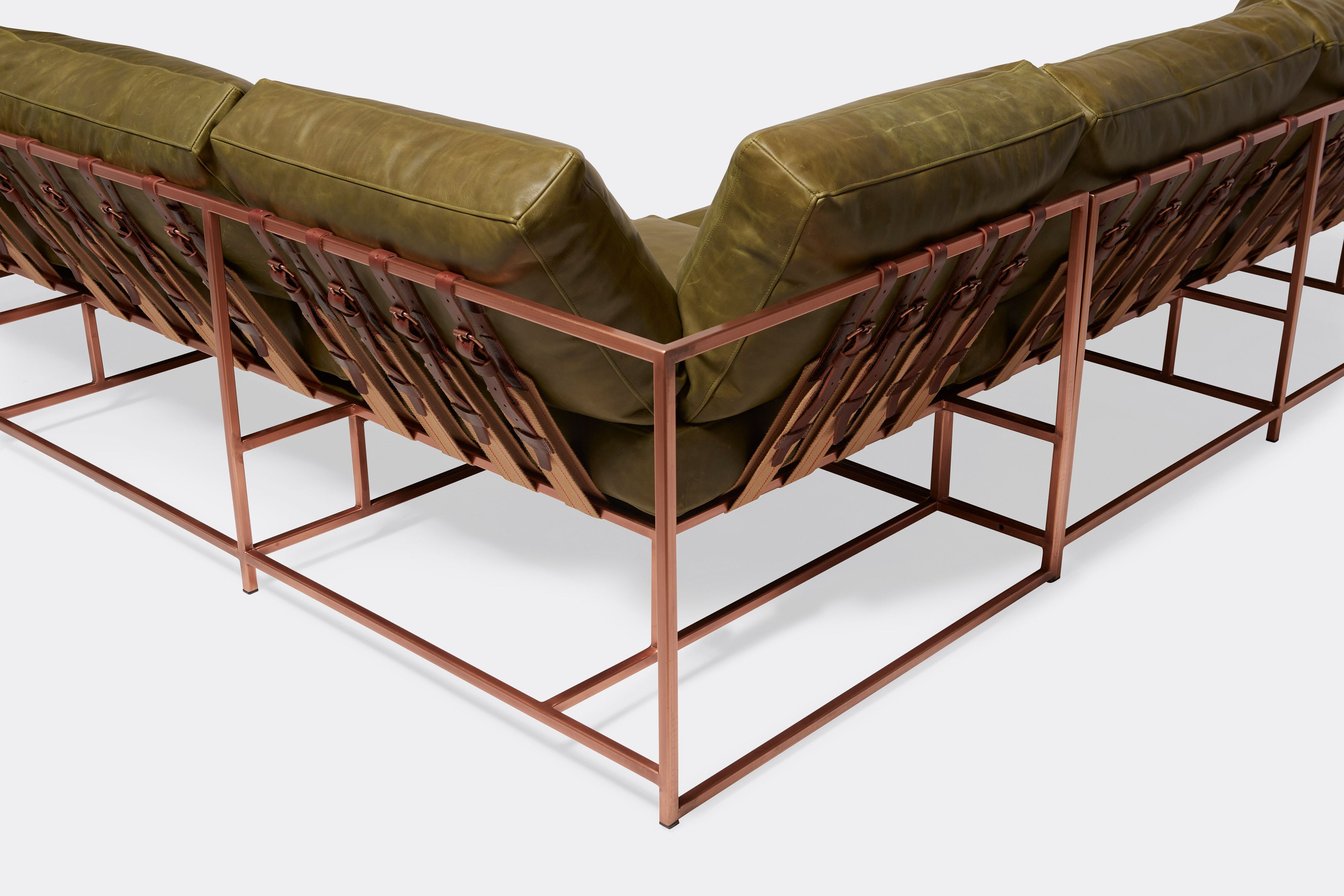 back of sectional with green leather upholstery on antique copper metal frame