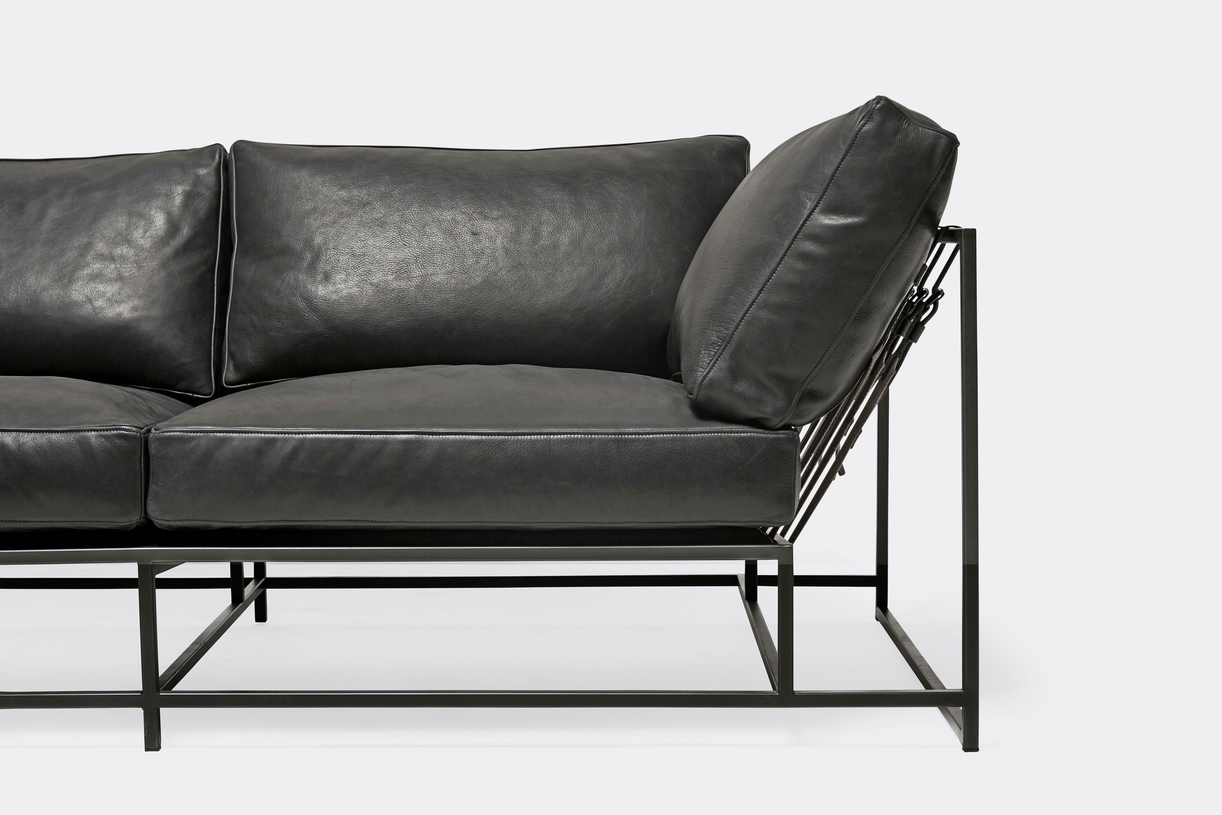 front detail of two seat sofa black leather upholstery and black metal frame