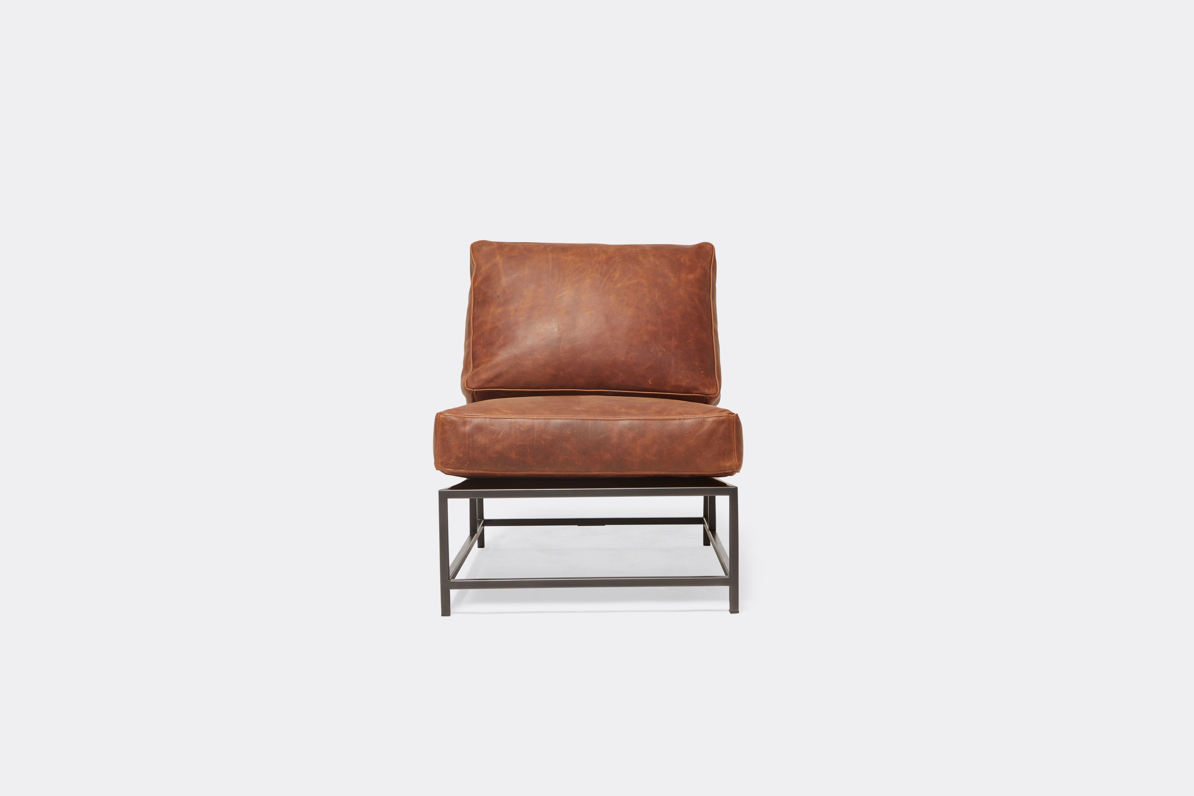 Front of lounge chair with brown leather upholstery and black metal frame
